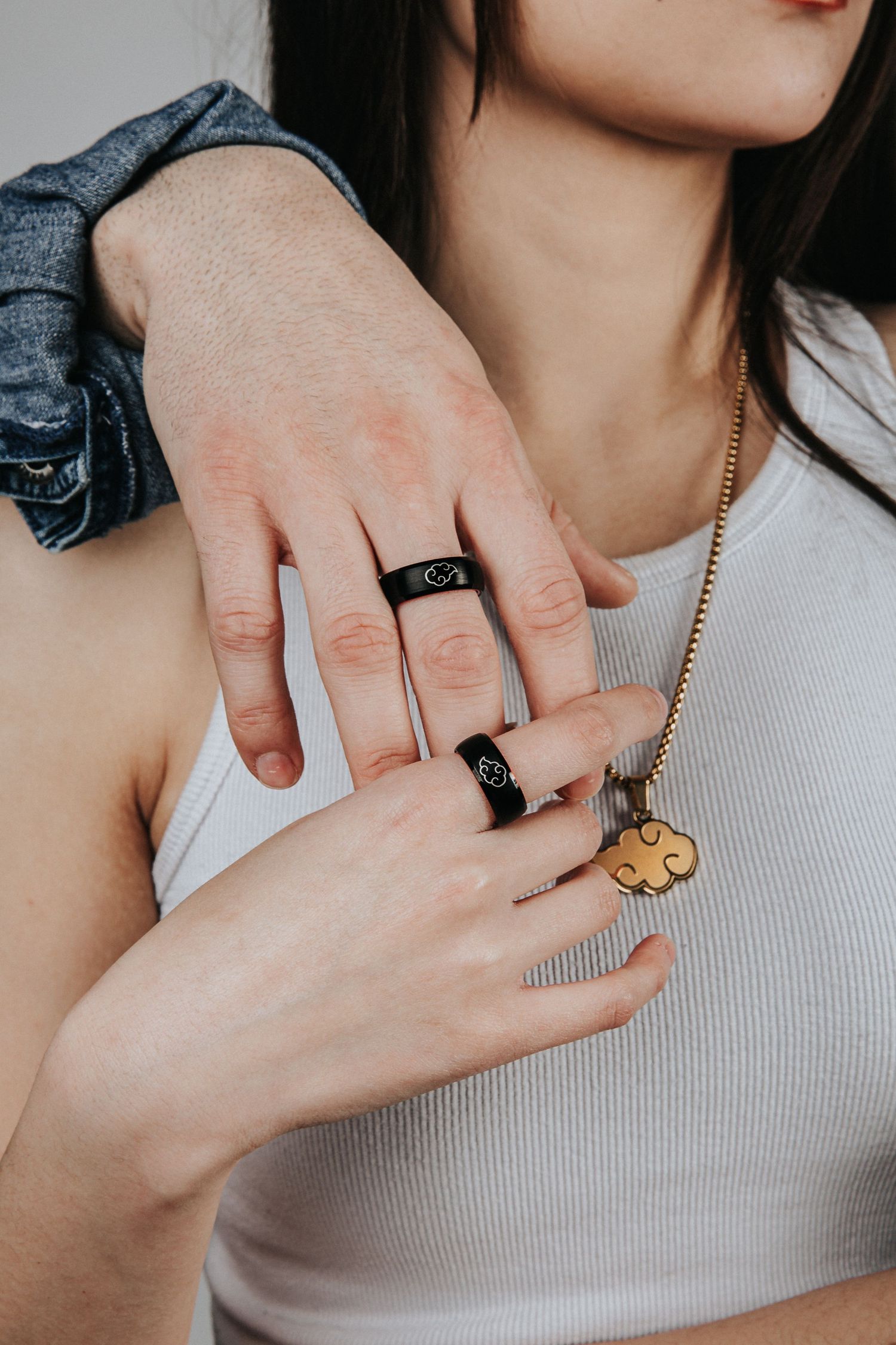 Series of close-up shots showing hands with rings and a delicate necklace on white clothing.