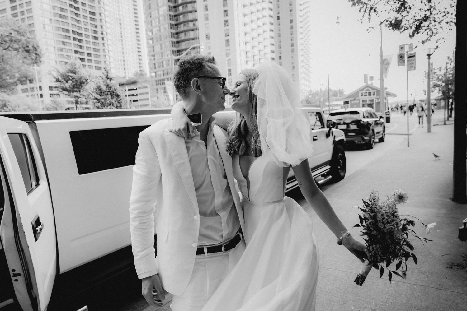 Urban wedding photos with city skyline and high-rise buildings in background.
