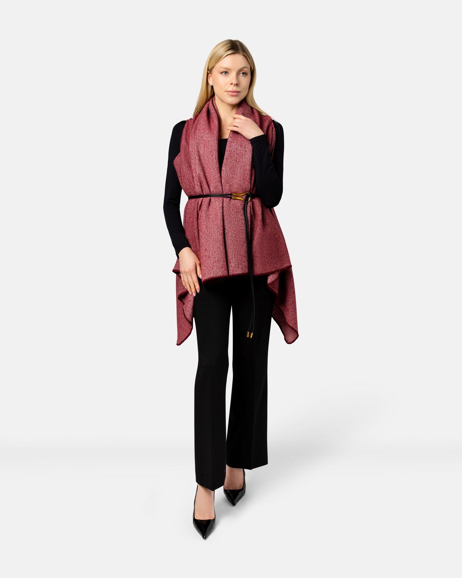 A model wearing a burgundy puffer vest paired with black pants and heels against a white studio background.