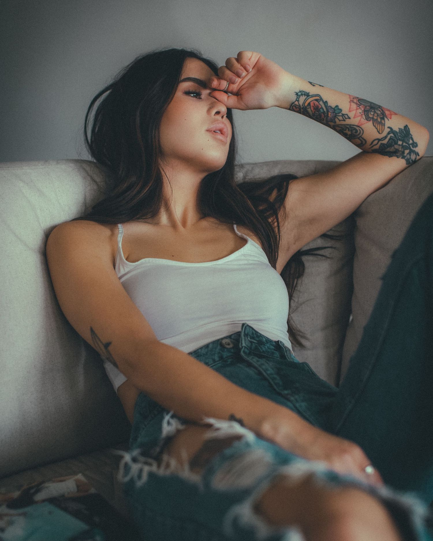 Artistic indoor photography session with relaxed poses on grey couch.