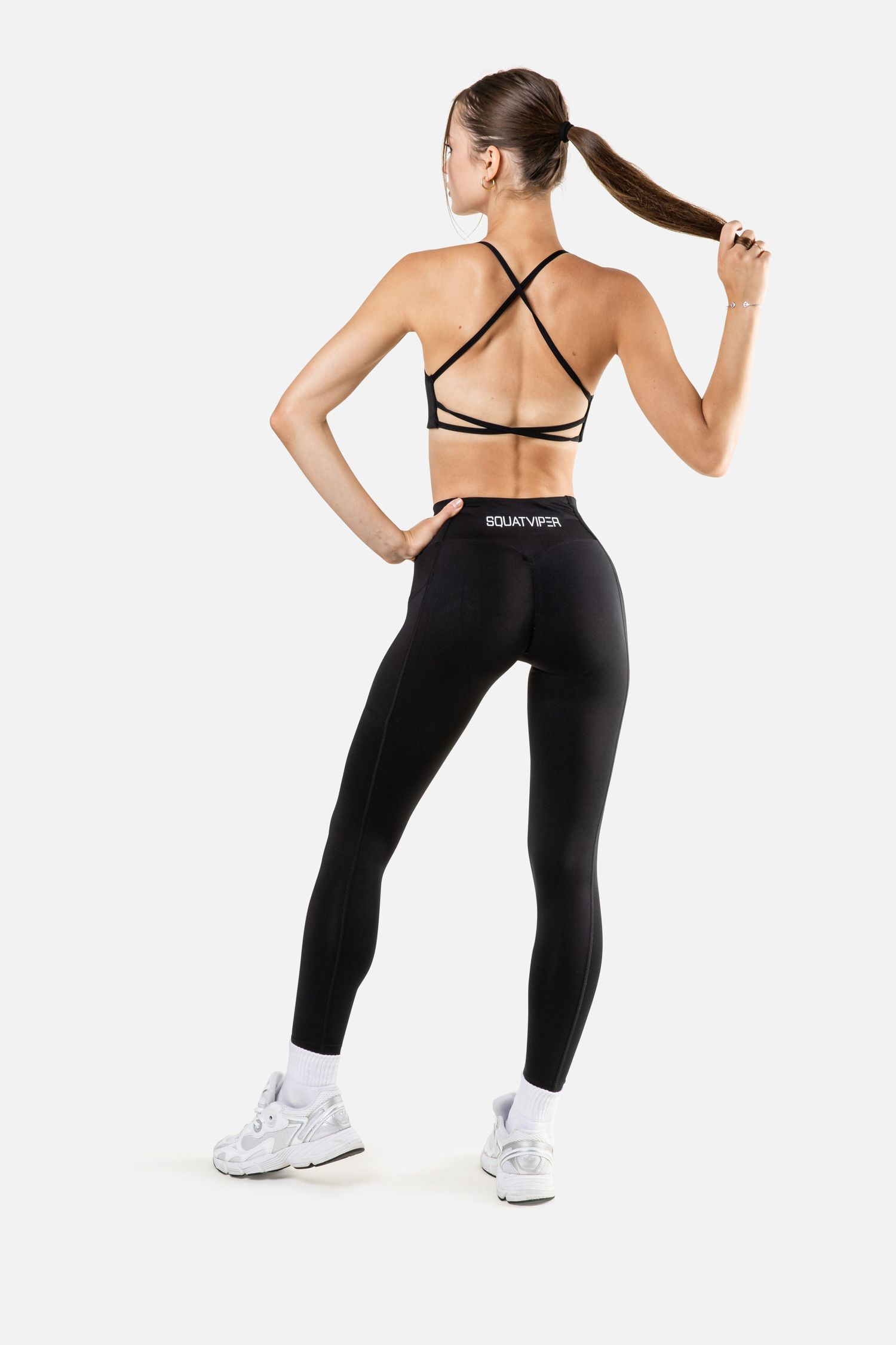 Black athletic leggings with cross-back sports bra shown in dynamic poses.
