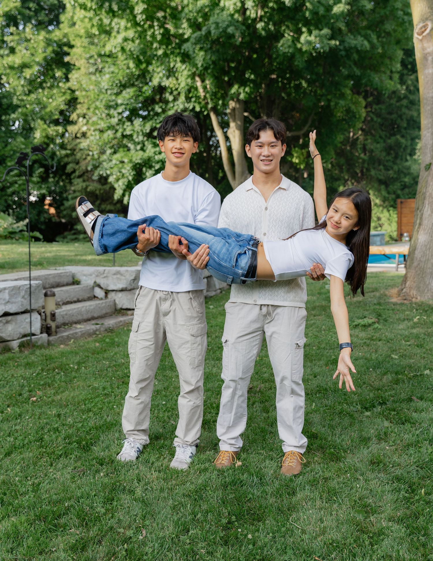 Fun outdoor family portrait with matching outfits on green lawn.