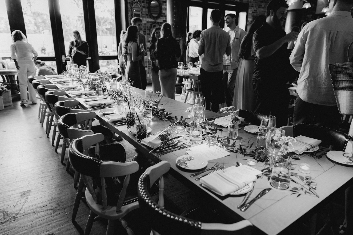 Black and white photo of a formal dining setup with place settings and glassware.