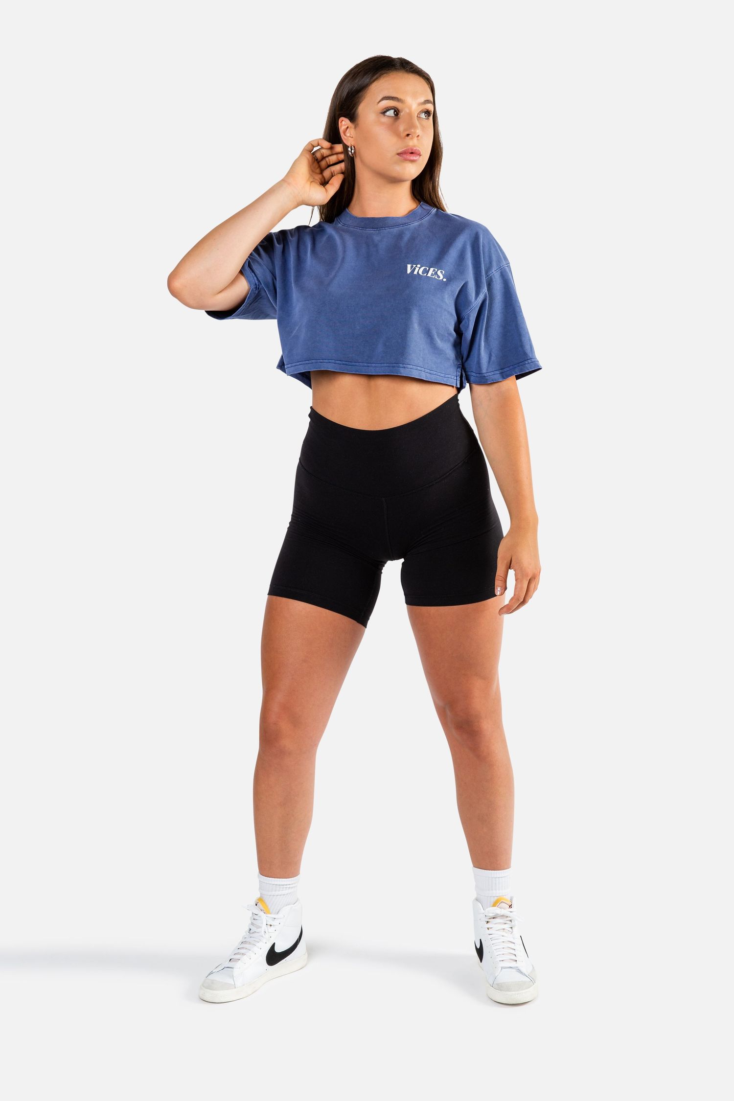 Athletic wear featuring blue crop top and black shorts shown in dynamic poses.