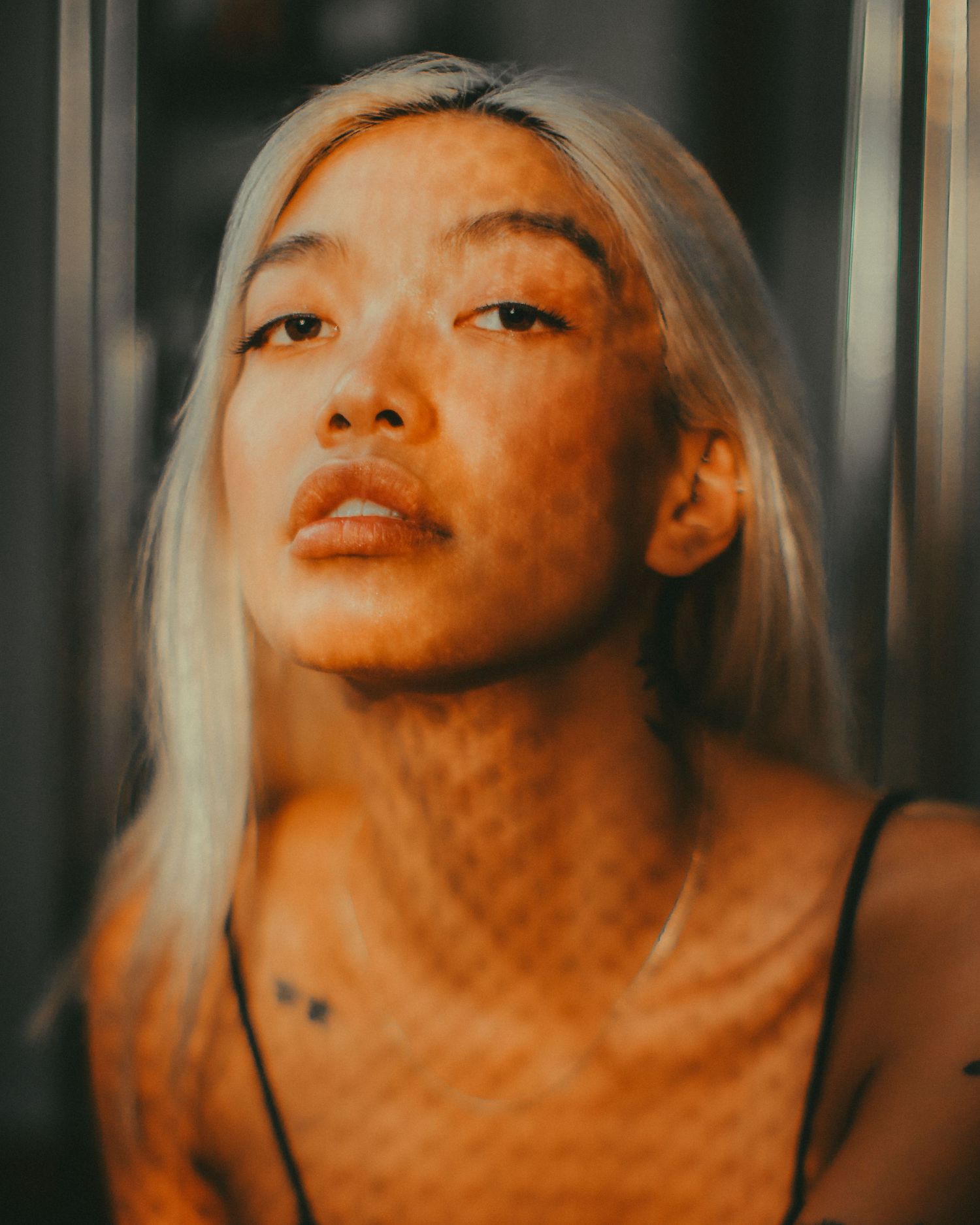 Close-up portrait series with orange lighting and textured shadow patterns.