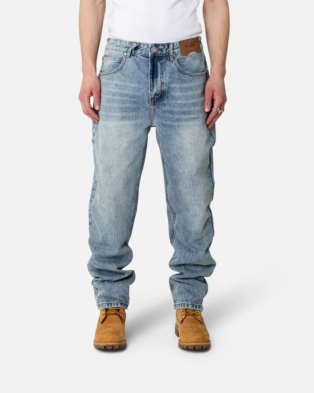 Light wash denim jeans with brown work boots shown from a low angle.