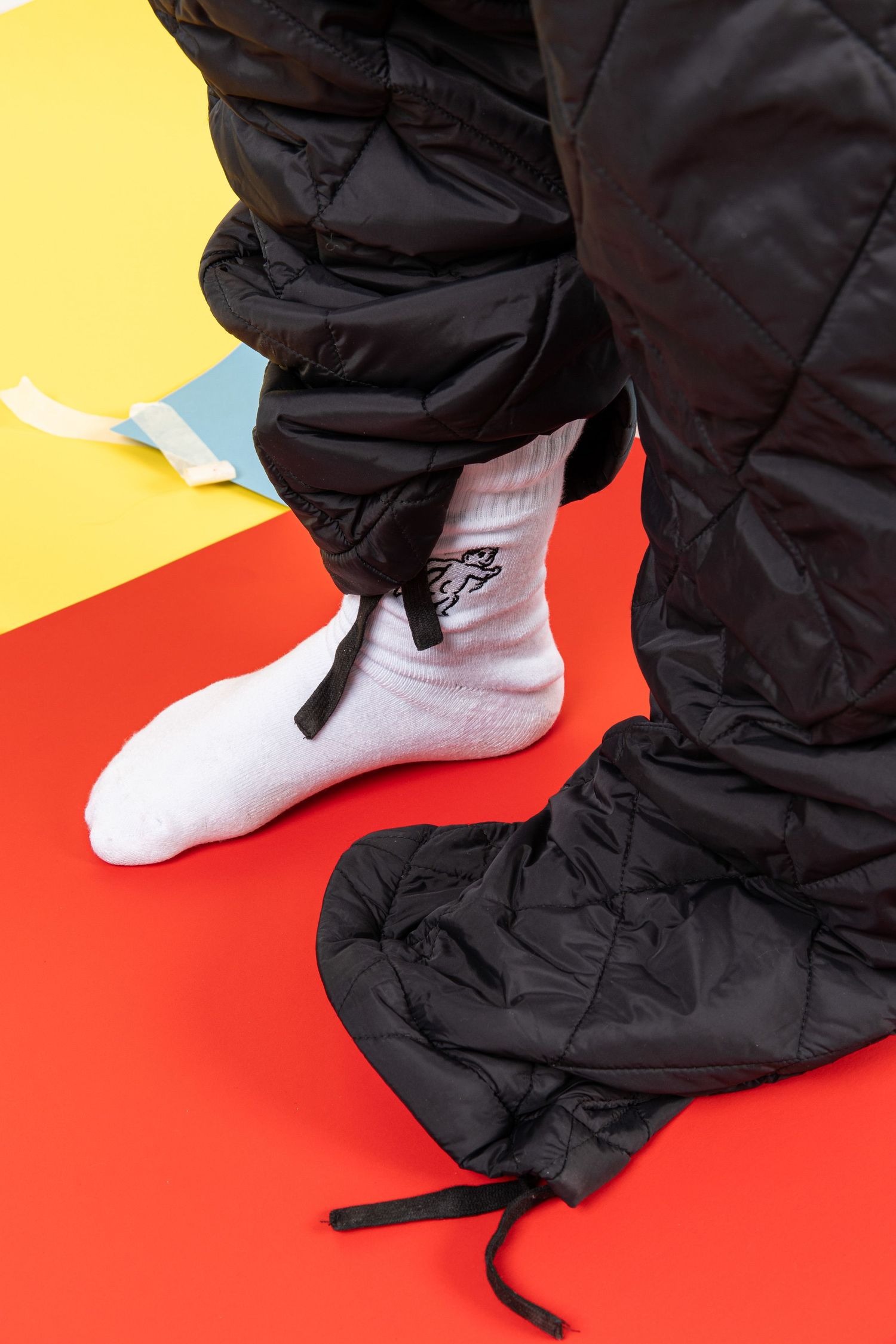 Black pants and white socks moving against yellow and red background in sequence.