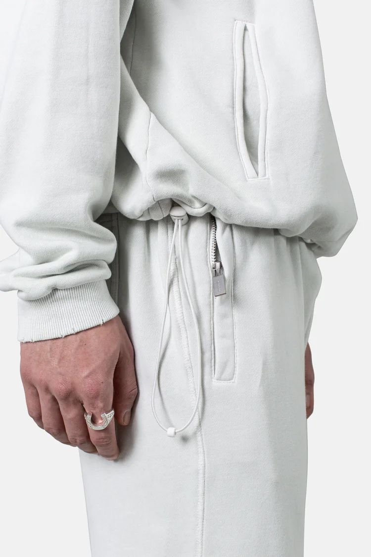 White sweatpants with drawstring waist detail shown against white background.