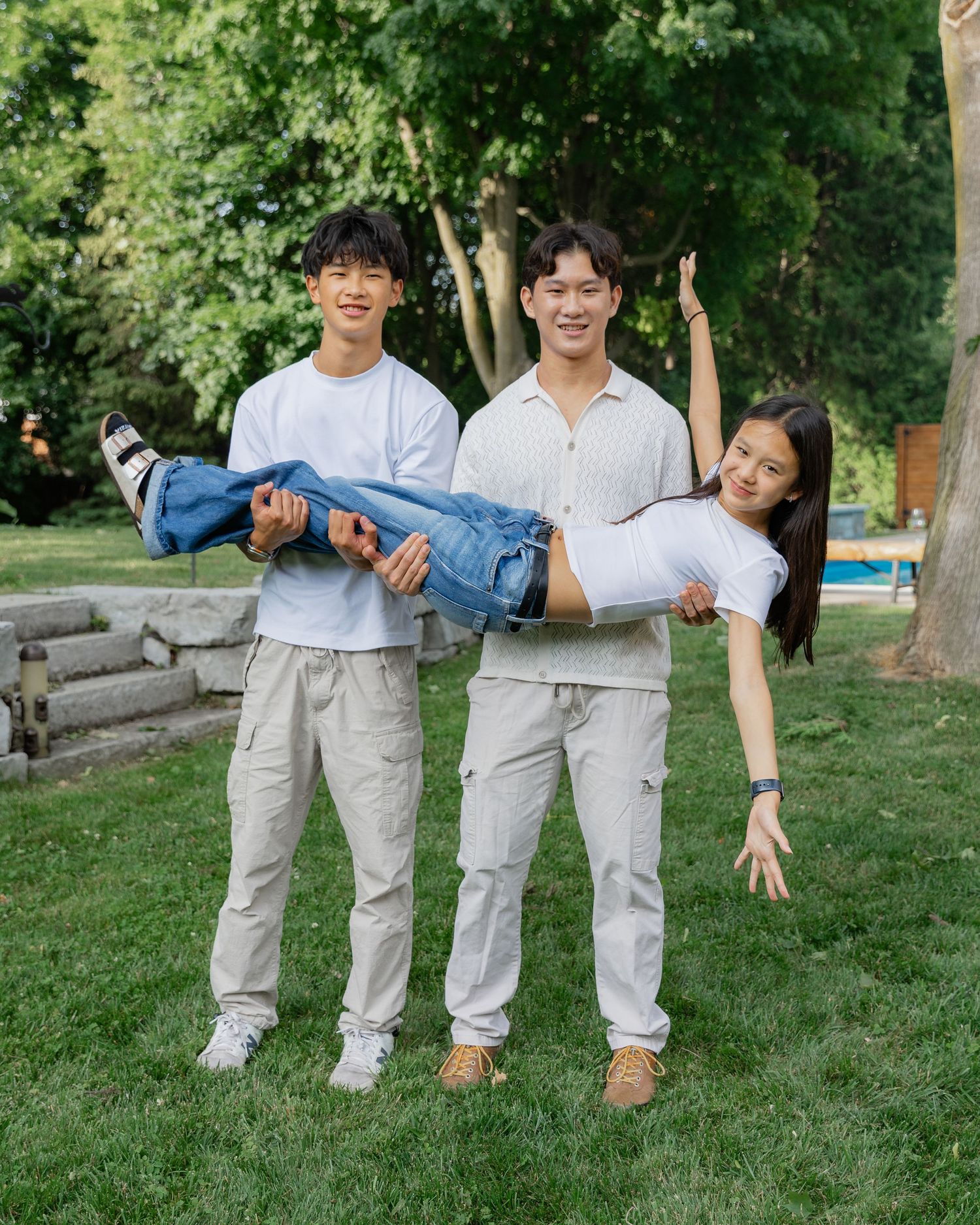 Family members in coordinated outfits pose playfully on grassy lawn.