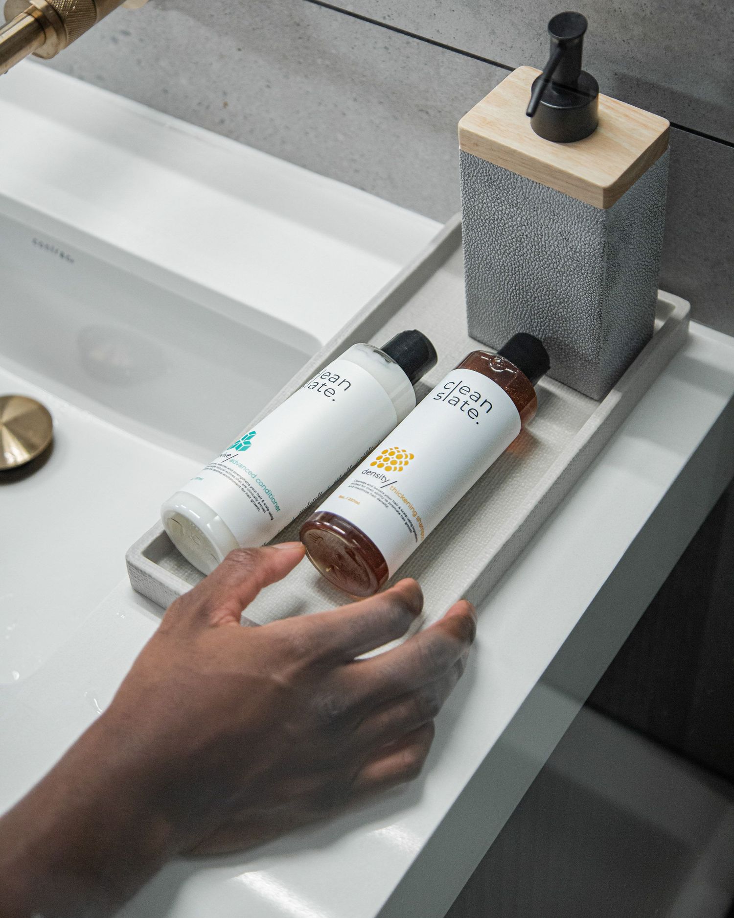 Multiple skincare product bottles arranged on white bathroom counter.