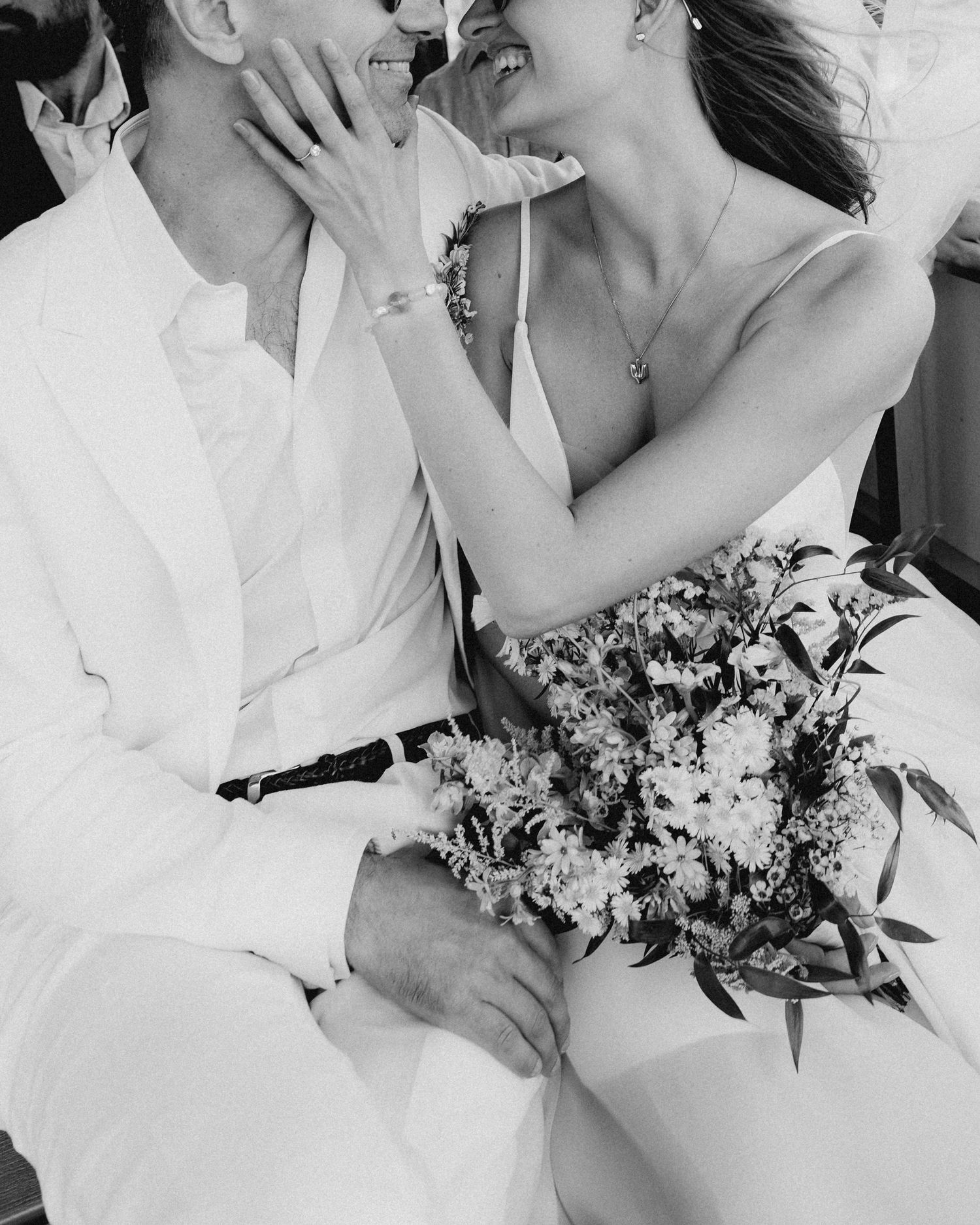 Black and white intimate wedding portrait with couple holding floral bouquet.