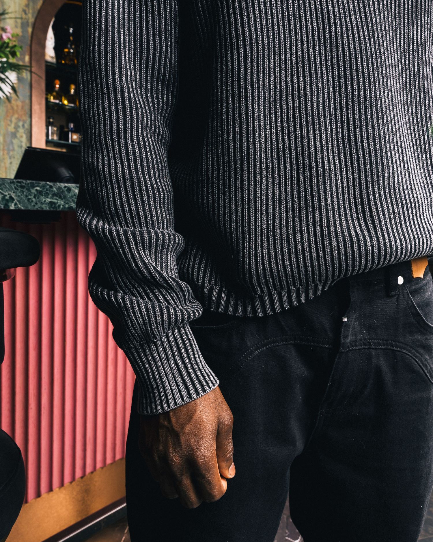 Close-up of black ribbed sweater and pants detail.