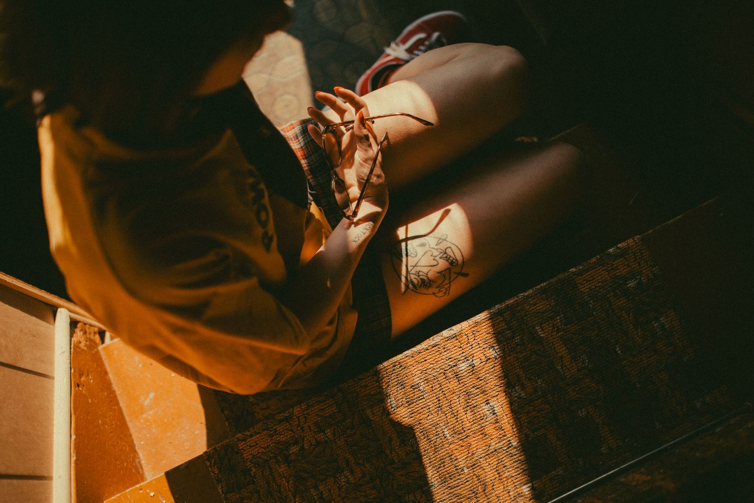 Artistic detail shot of boots in dramatic lighting on wooden surface.