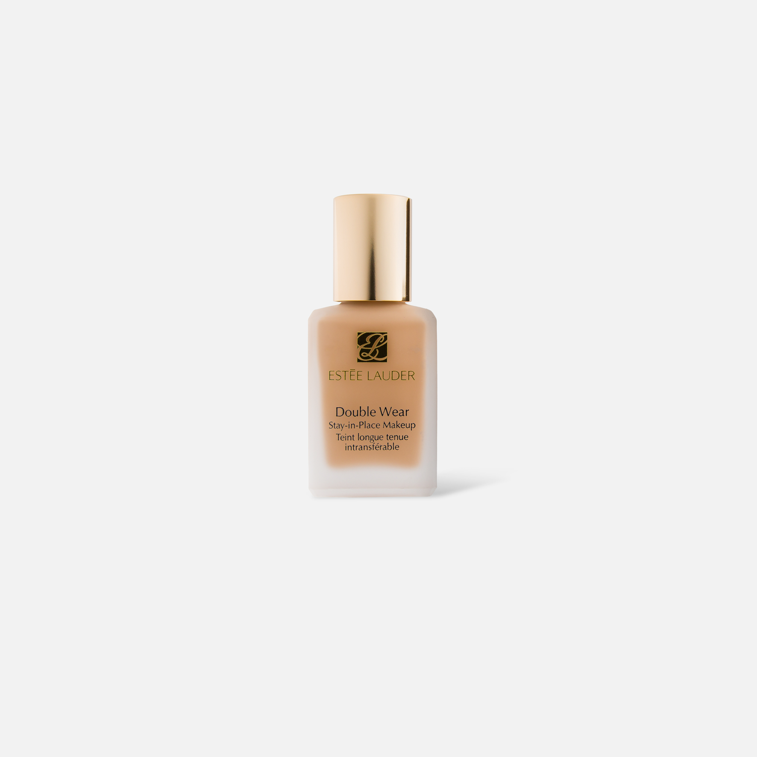 Glass bottle of luxury foundation makeup in beige tone against white background.