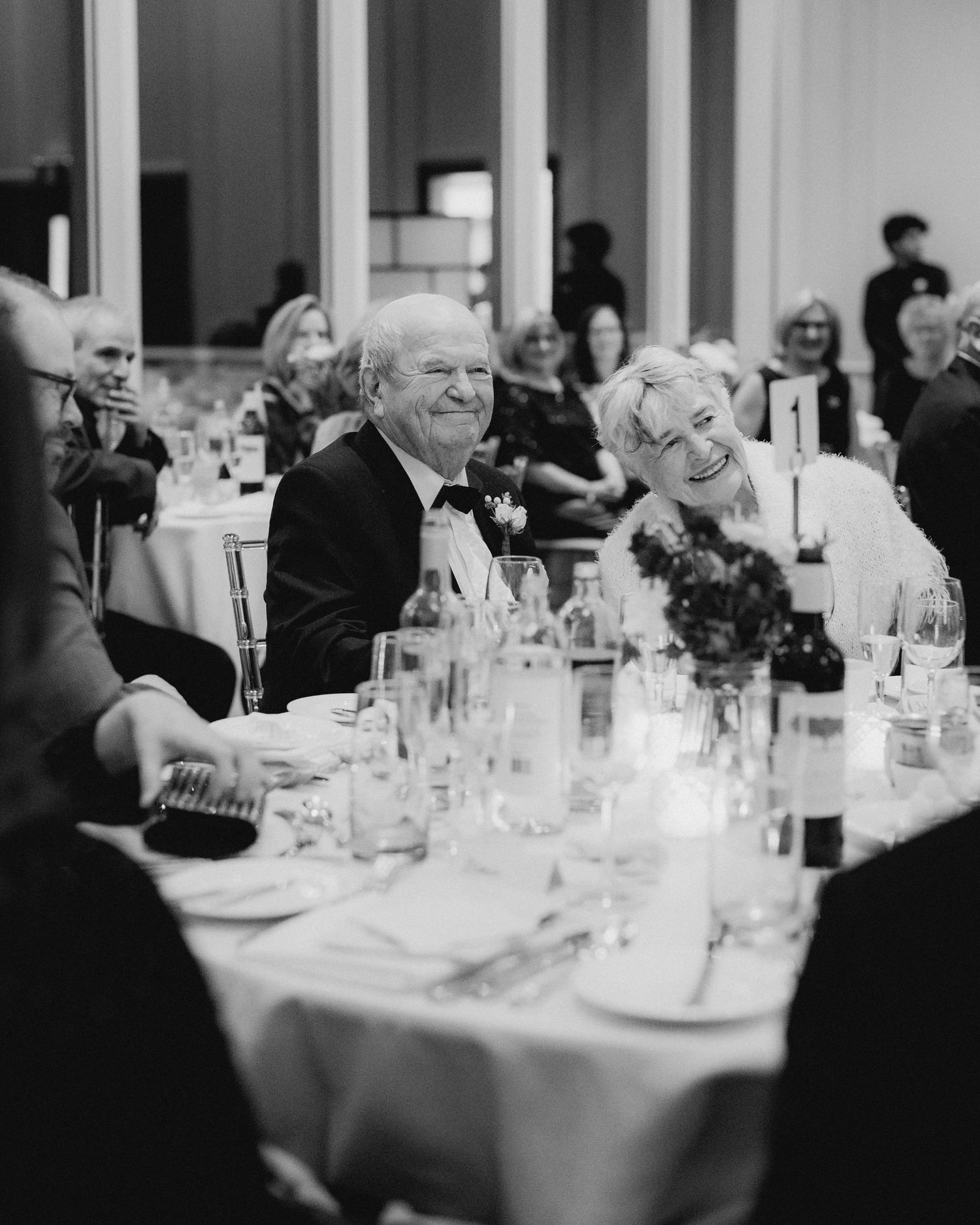 Black and white image of elegant table settings at a wedding reception.
