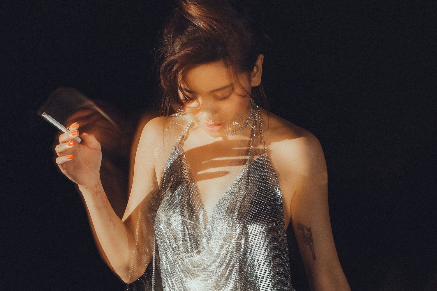 Glamorous evening portrait with sparkly silver dress against dark background.