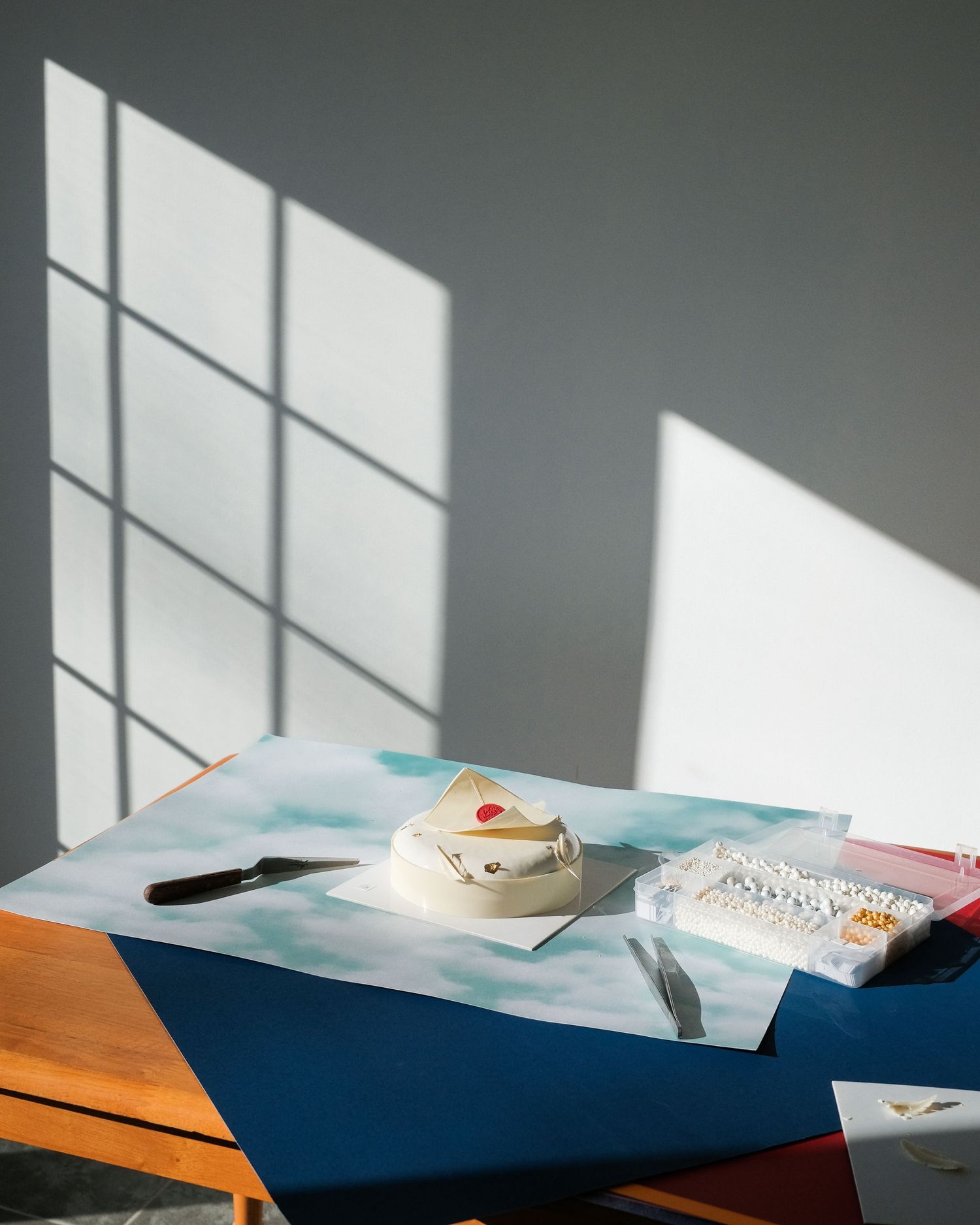 Sunlight casting geometric shadows across a blue surface with decorative elements.