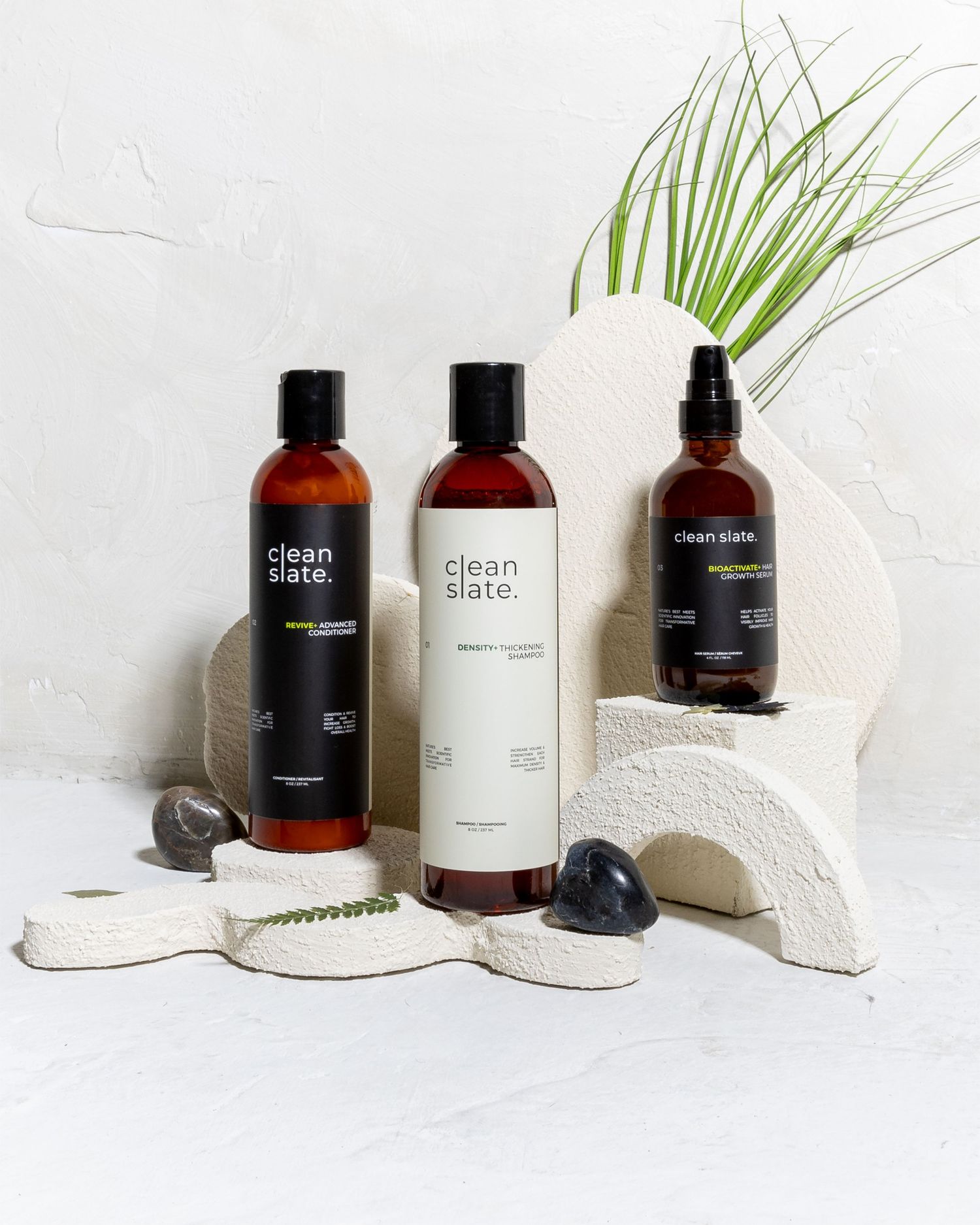 Minimalist skincare product bottles arranged with palm leaves against white background.