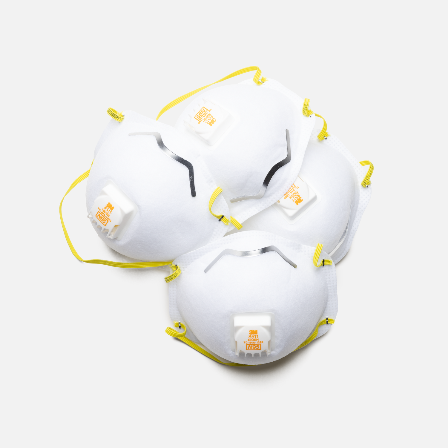 Broken white ceramic pieces with yellow accents scattered on white surface.