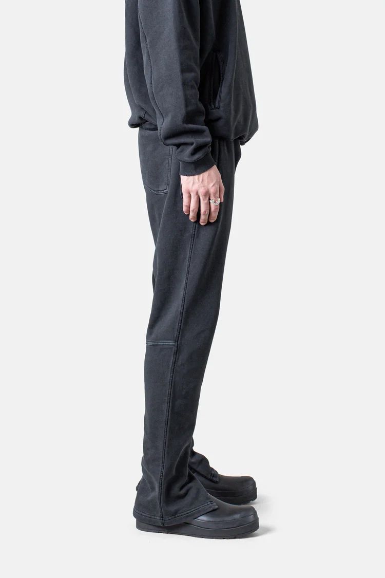 Dark gray sweatpants and black shoes shown from side view.