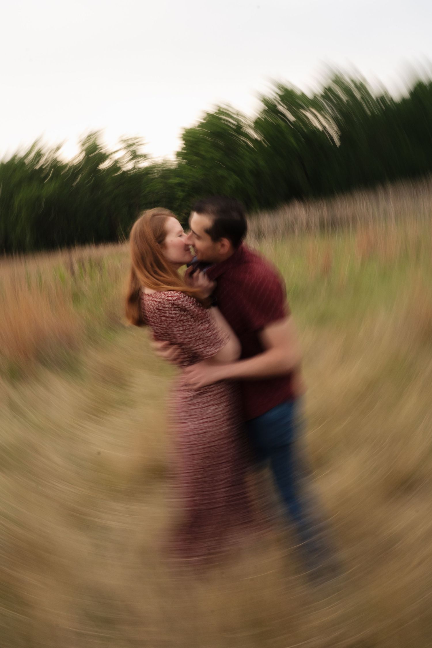A couple on their engagement shoot in a field, photo taken by Jordie Captures