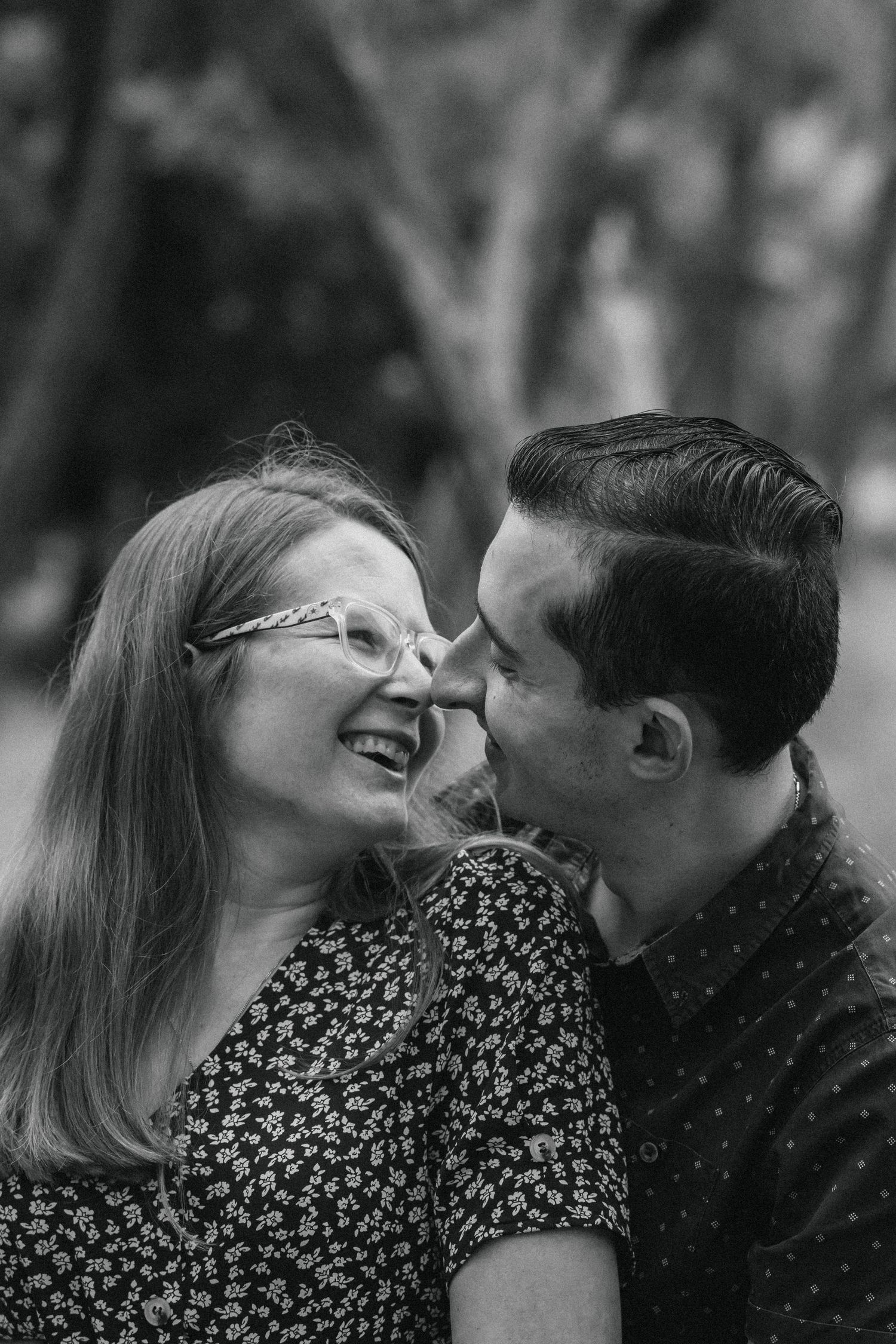 A couple on their engagement shoot in a forest, photo taken by Jordie Captures