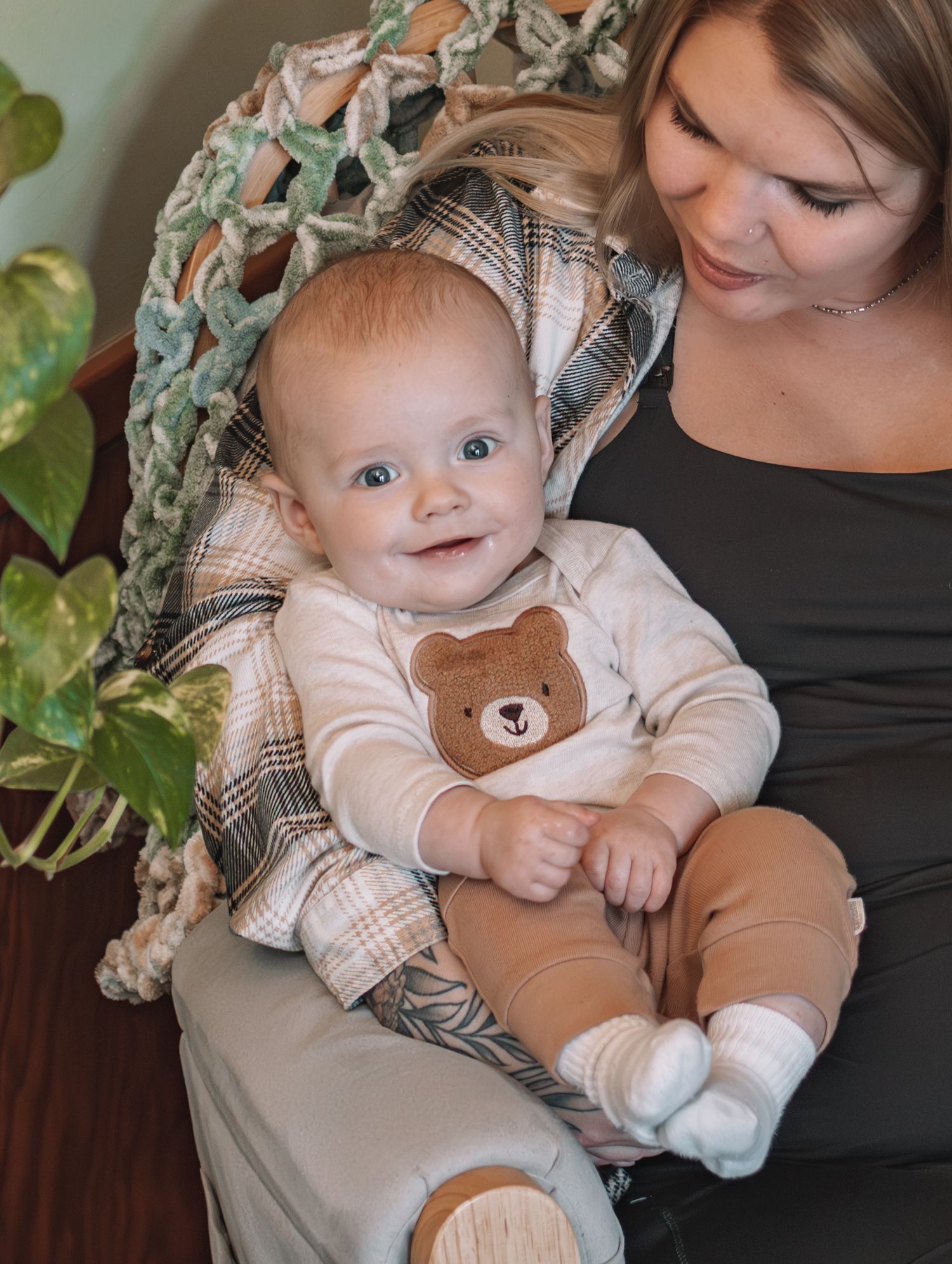Baby wearing white and brown bear outfit cuddles plush toy while being held in multiple candid moments.