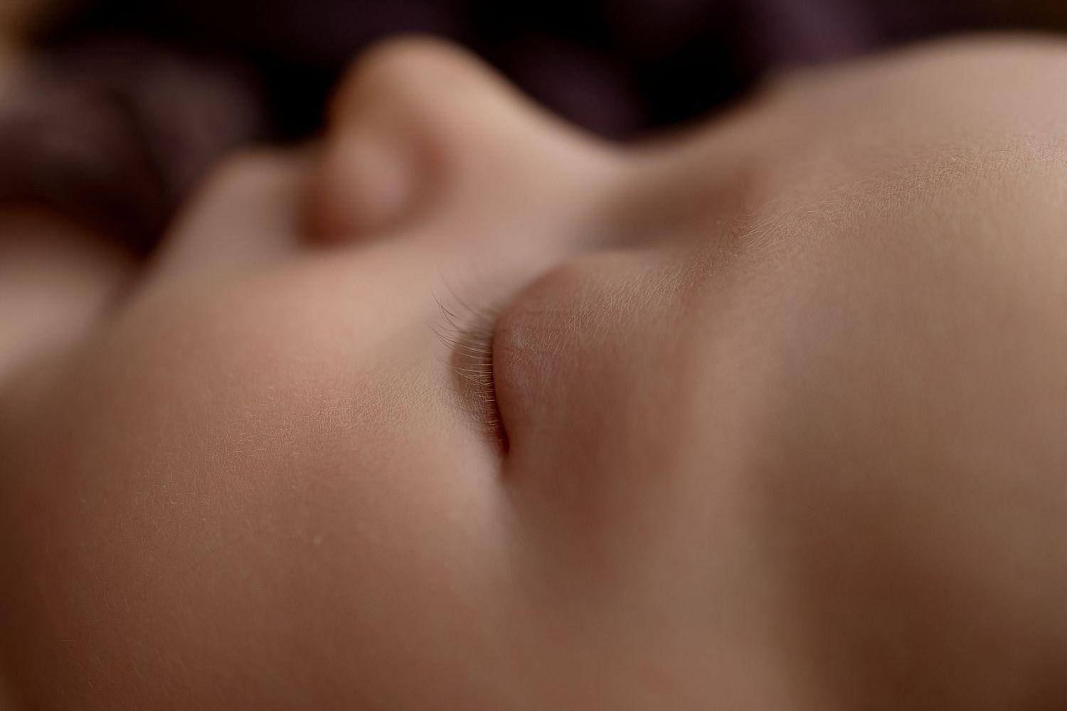 Extreme close-up of a peaceful sleeping newborn baby's face showing delicate skin and tiny features.