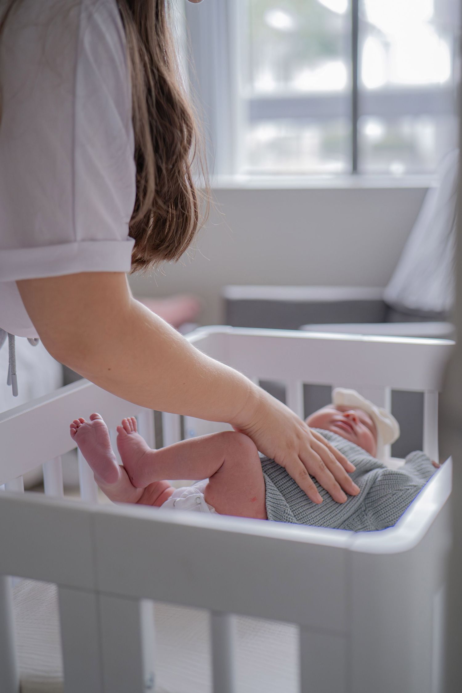 White wooden crib in a bright nursery room with natural light.