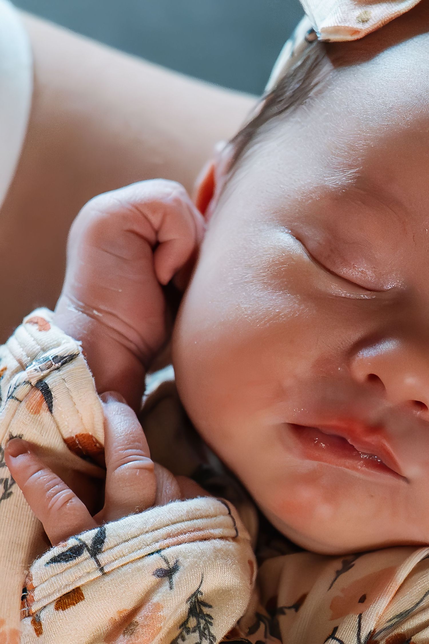 Peaceful sleeping baby wearing a patterned outfit.