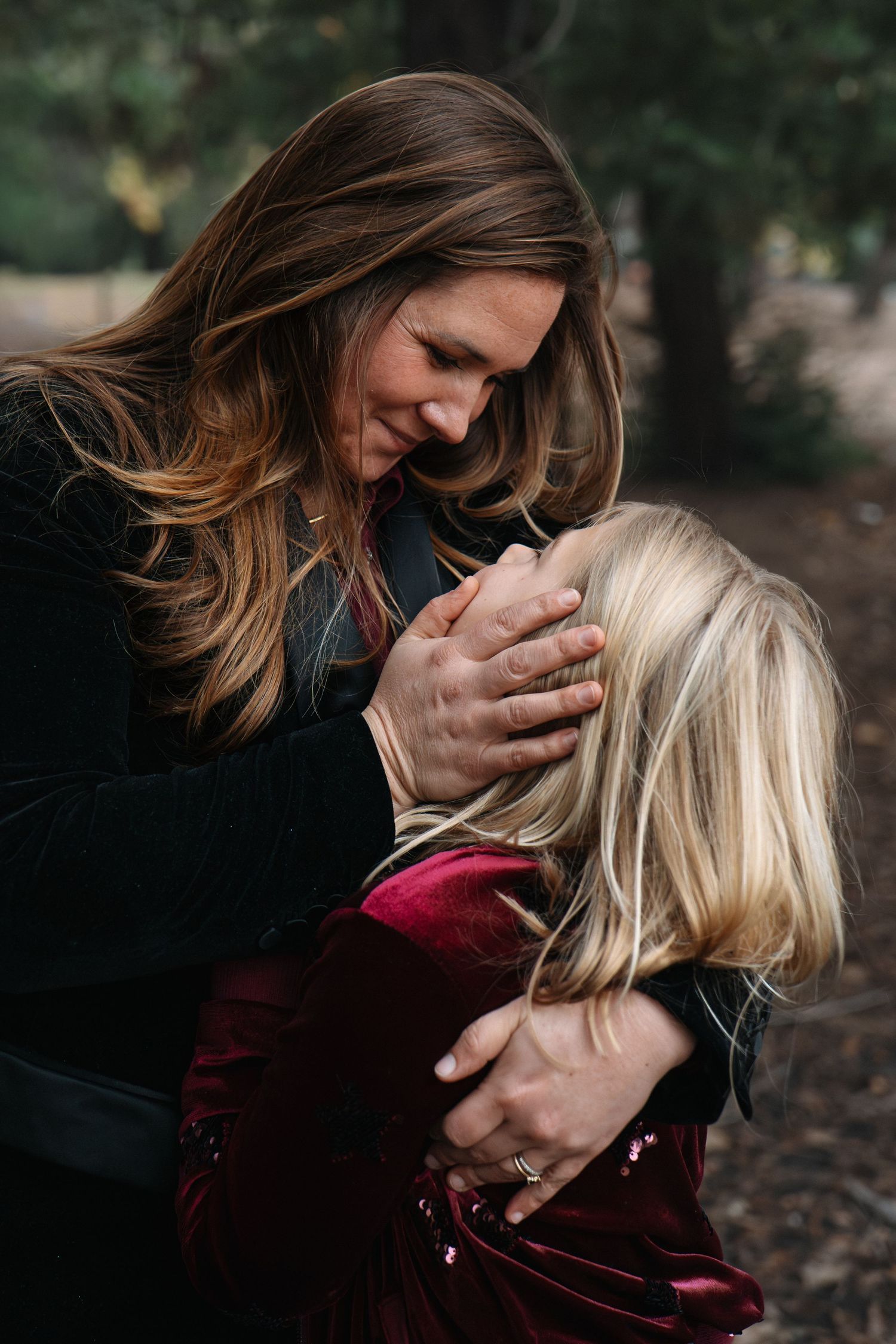 Intimate family moment captured in a series of tender embraces against a dark outdoor background in Roseville, CA