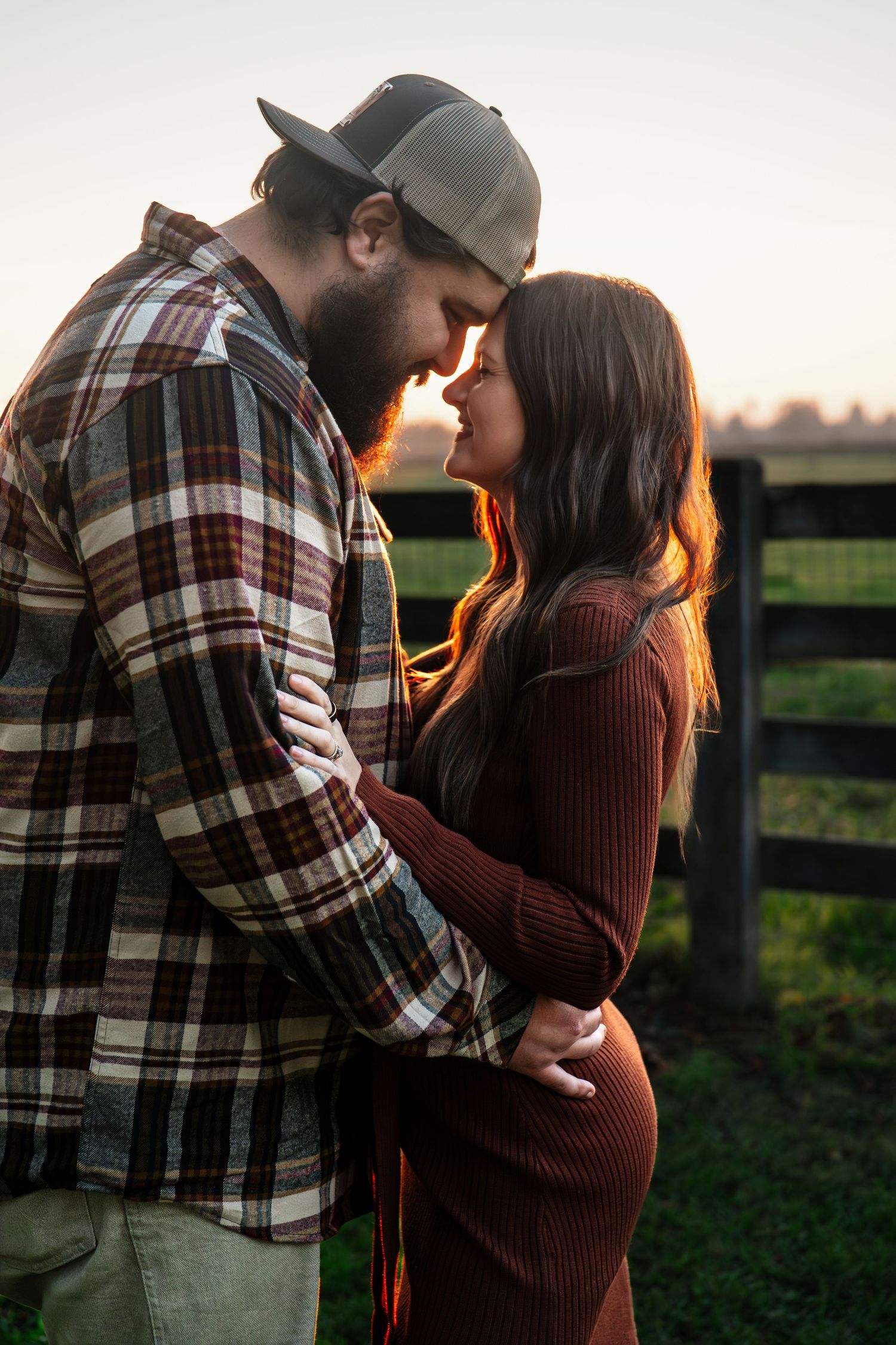 Intimate moments between couple wearing plaid and burgundy against sunset backdrop in Roseville, CA