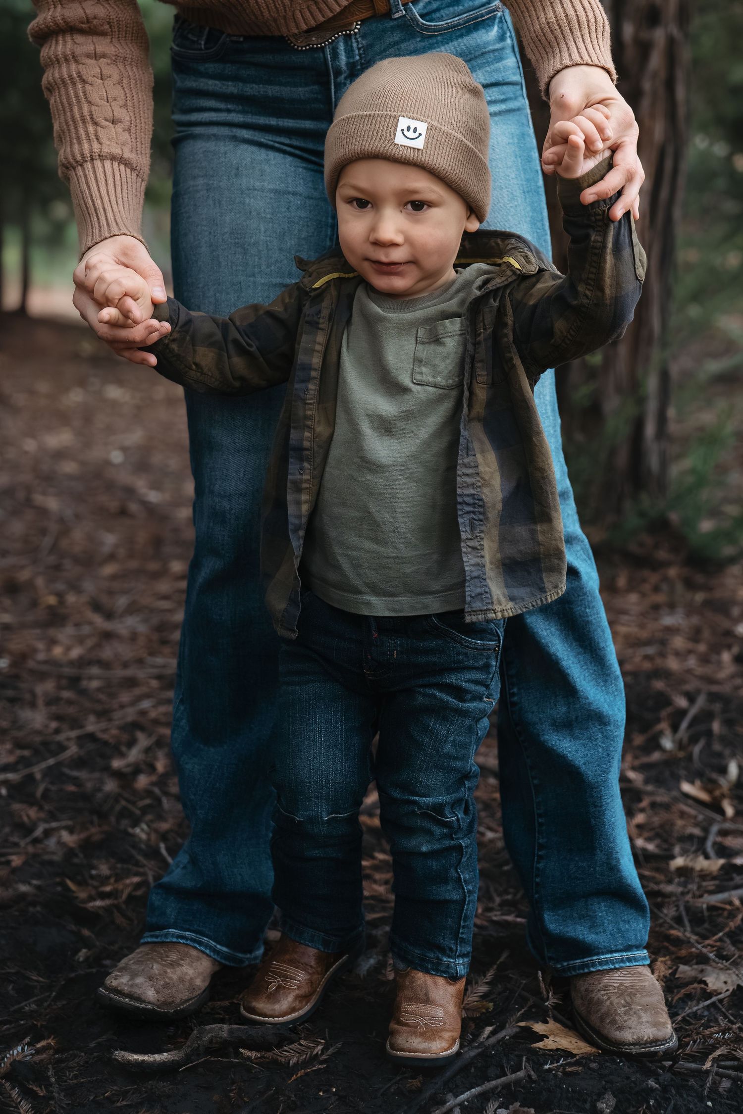 Small boots and denim-clad legs walking together on forest ground, in Roseville, CA