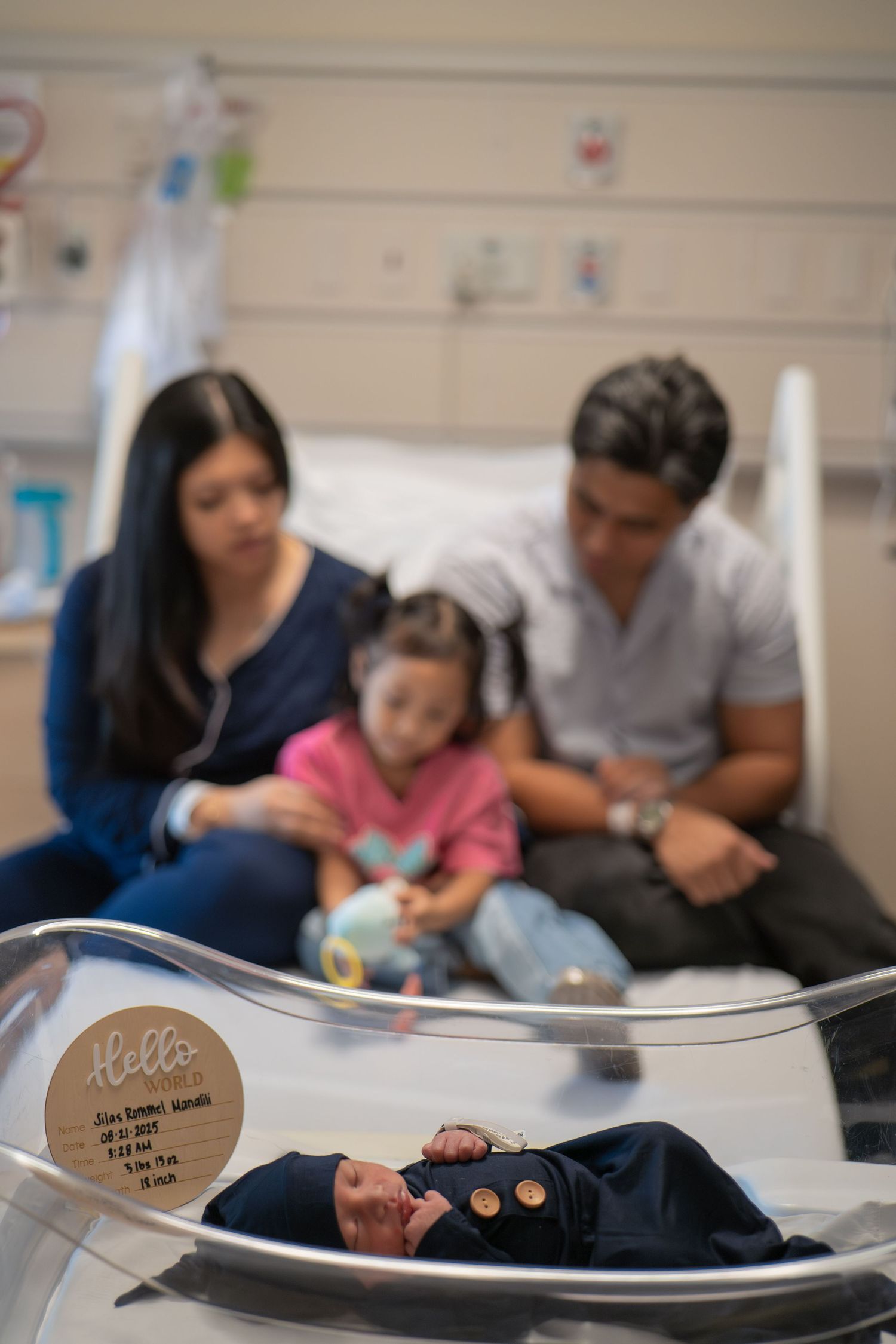 Hospital room scene with ultrasound equipment and family members gathered around.