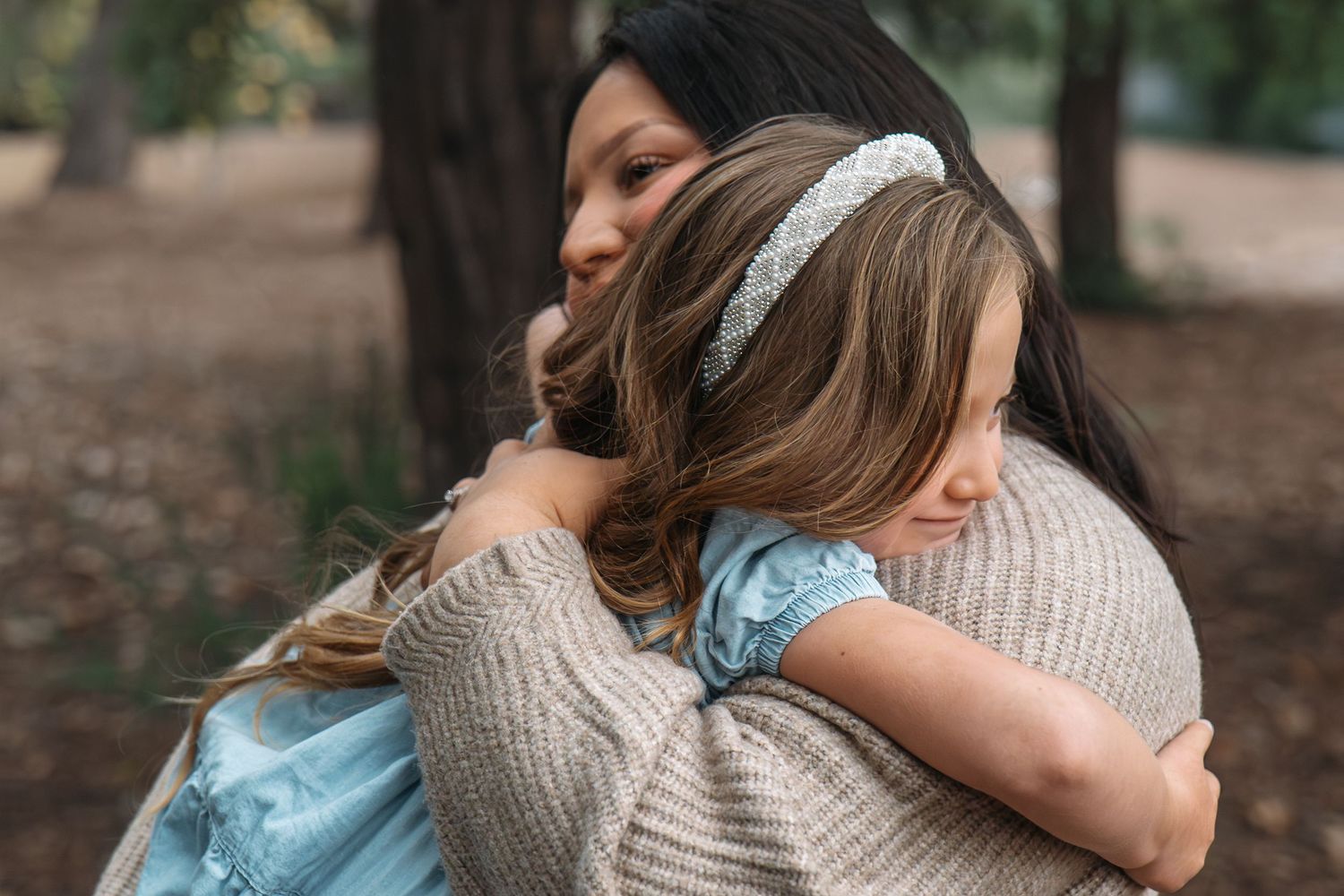 Candid family moments captured in soft natural lighting among trees in Roseville, CA