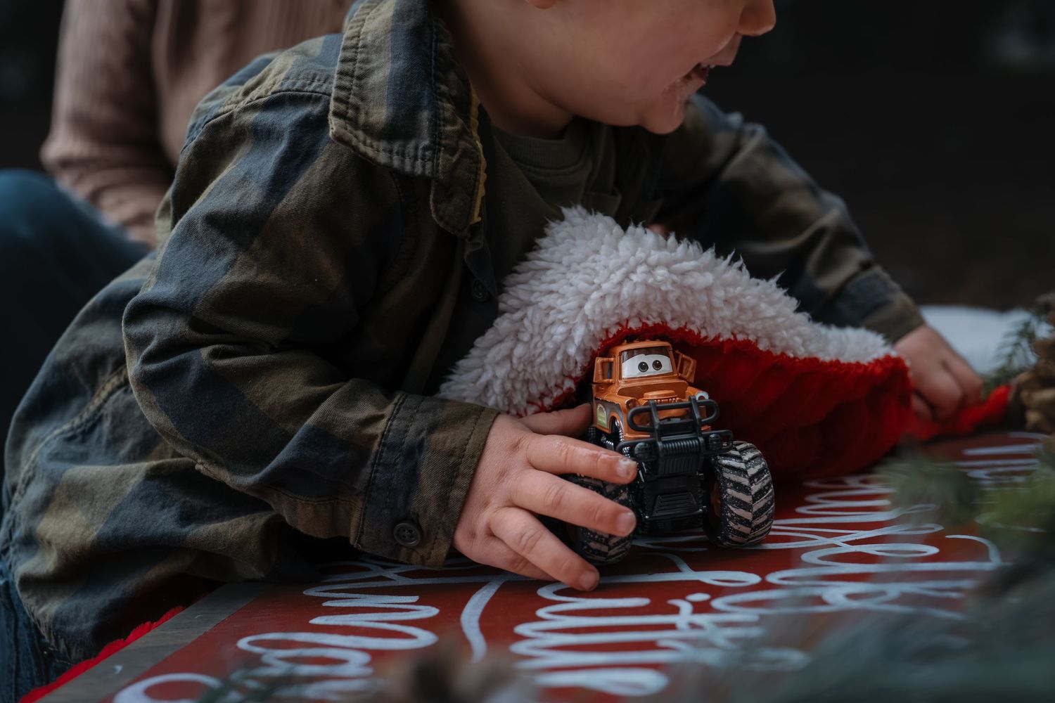 A small toy car being played with on a textured surface in dim lighting in Roseville, CA