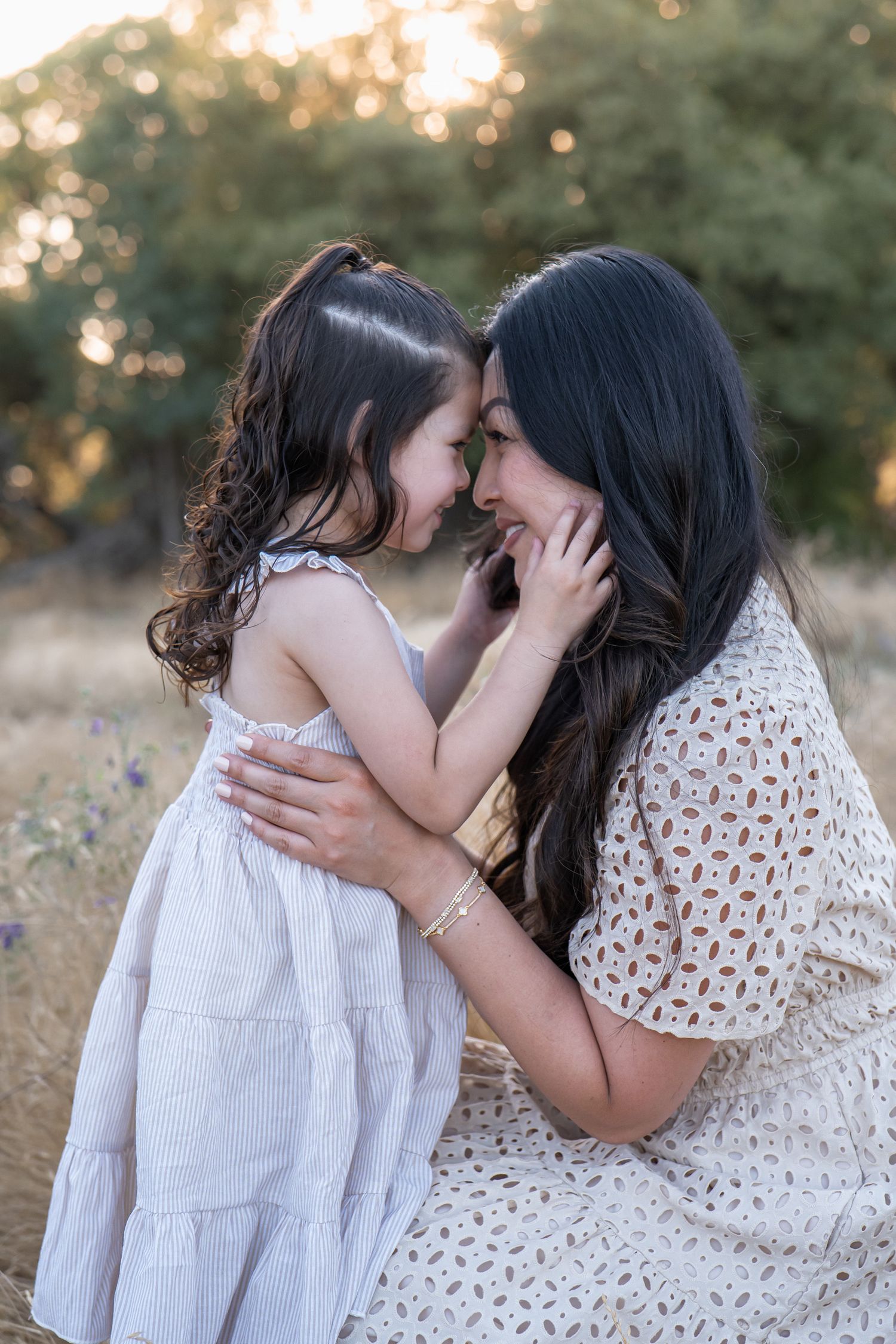 Intimate family moments captured in white dresses against golden sunset field.