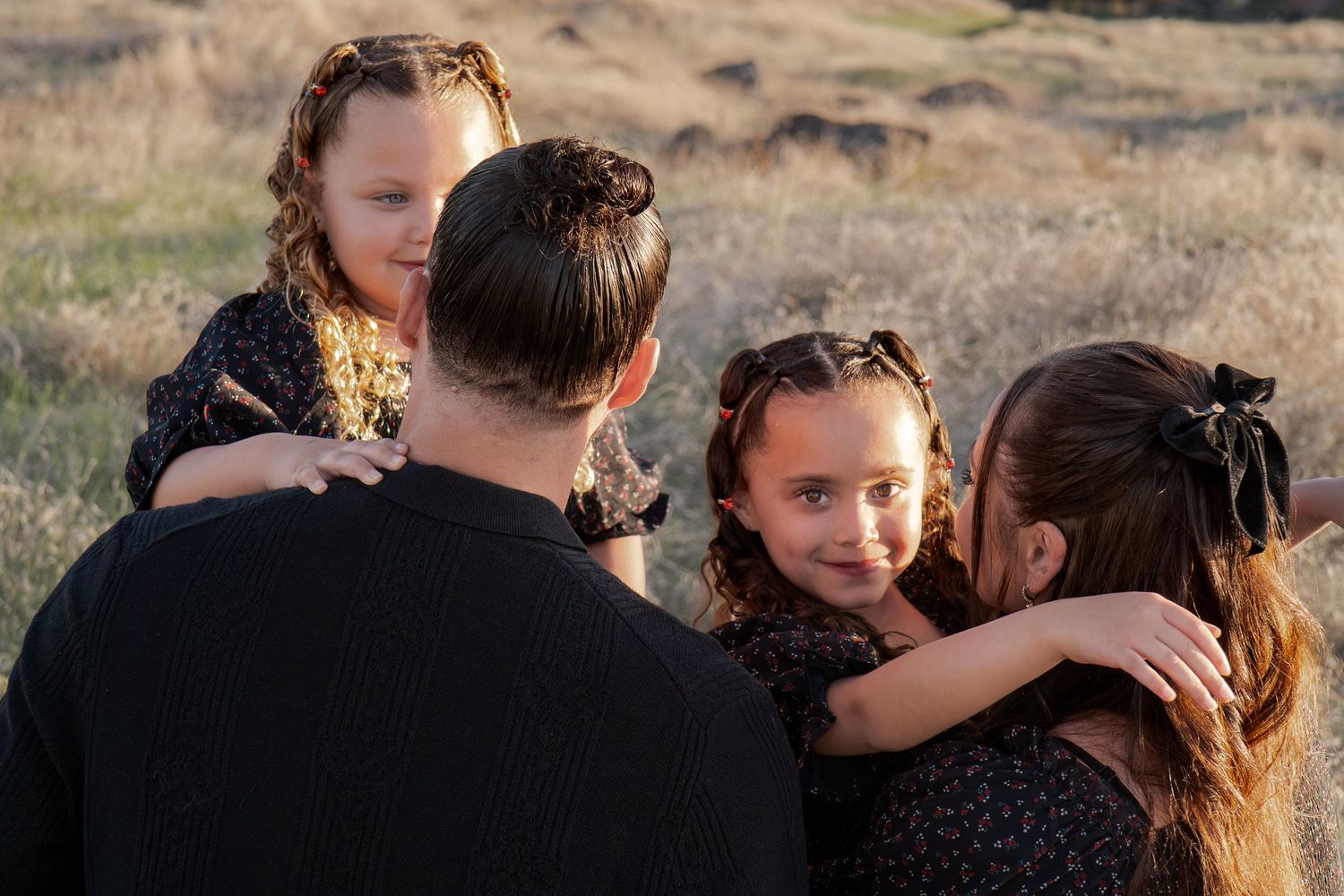 Intimate family embrace captured during sunset in rustic outdoor setting in Roseville, CA