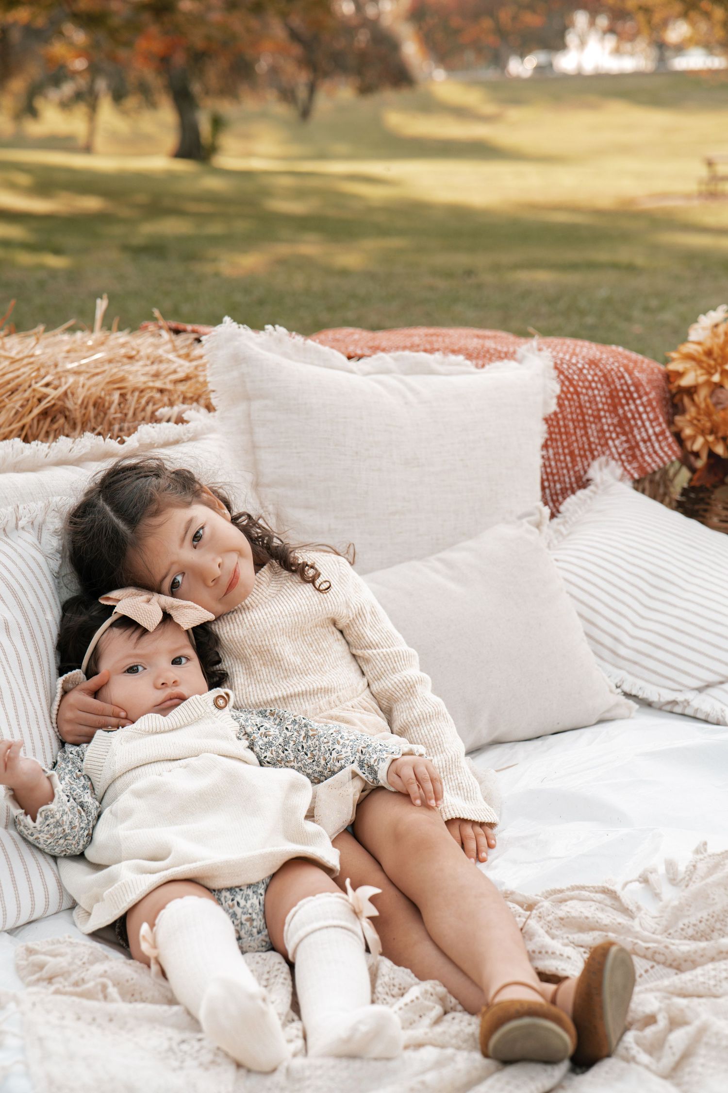 Sweet moment captured on white blanket with soft pillows during outdoor autumn photoshoot in Roseville, CA