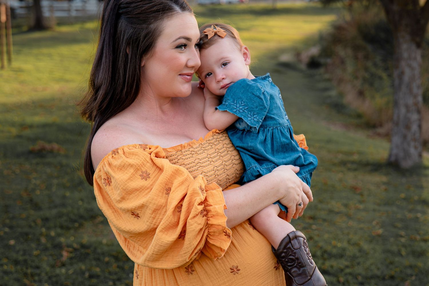 Mother and child share tender moment outdoors in coordinating yellow and blue outfits in Roseville, CA