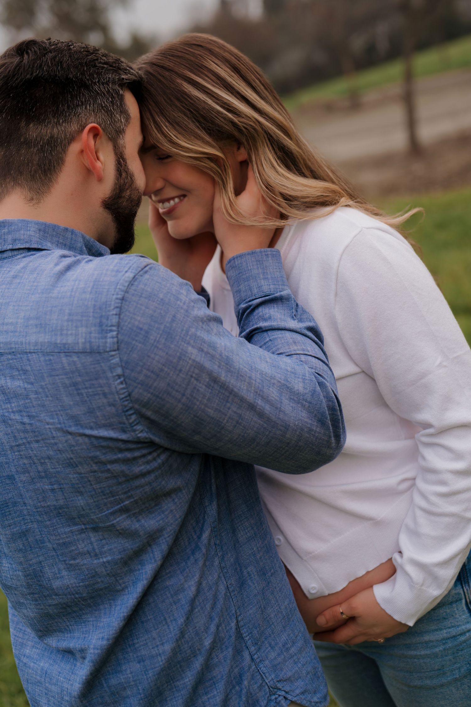 A sequence of intimate moments between a couple embracing outdoors, wearing blue and white casual attire.