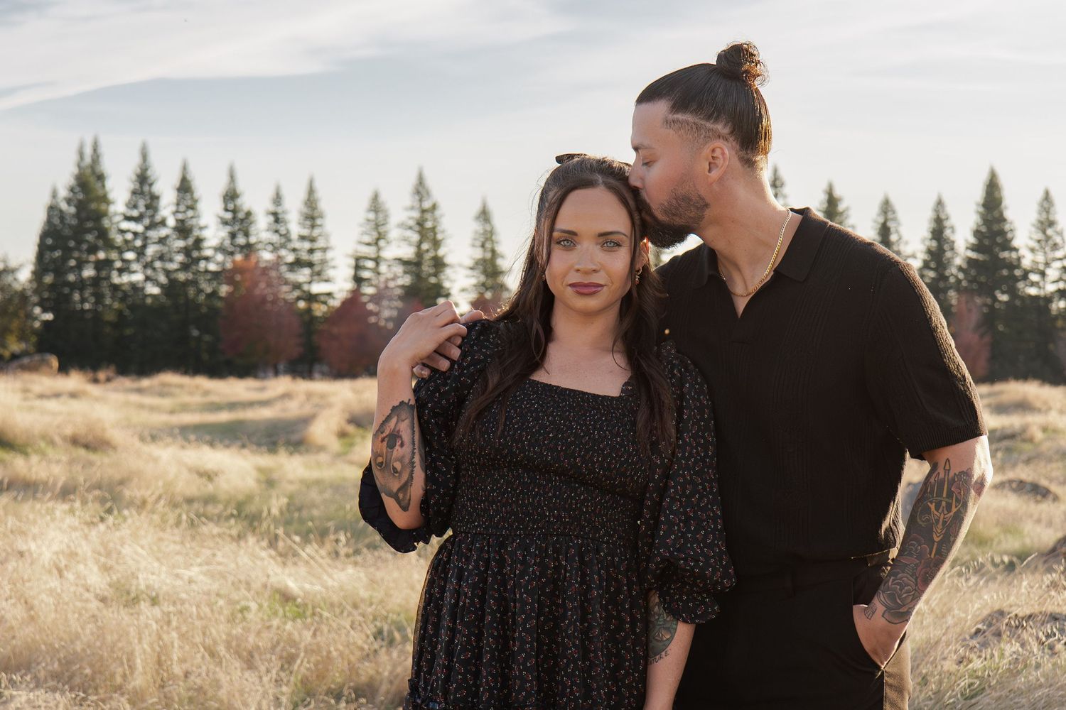 Couple in black outfits sharing tender moments against a natural outdoor backdrop in Roseville, CA