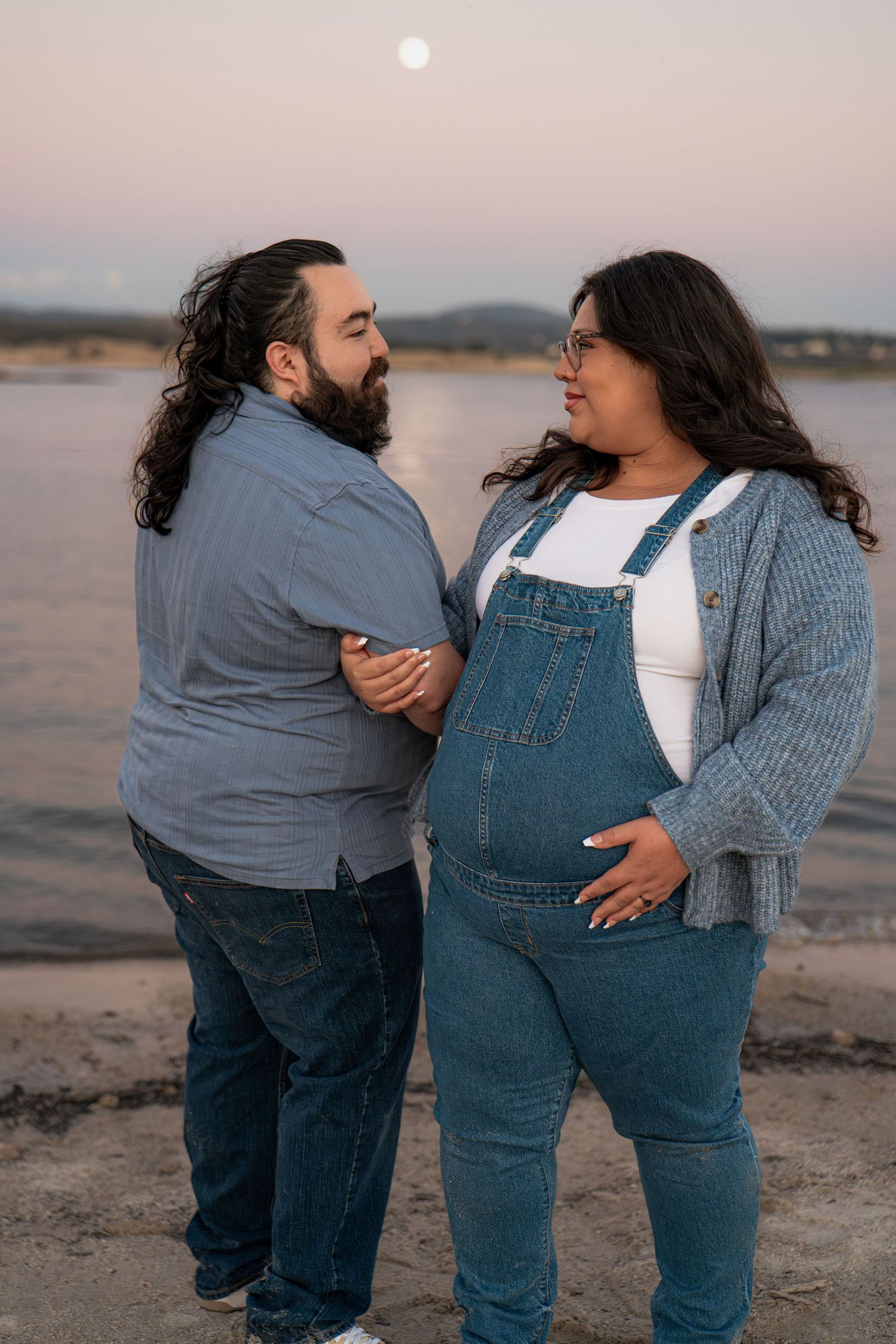 Couple in casual denim outfits share intimate moment on beach at dusk in Roseville, CA