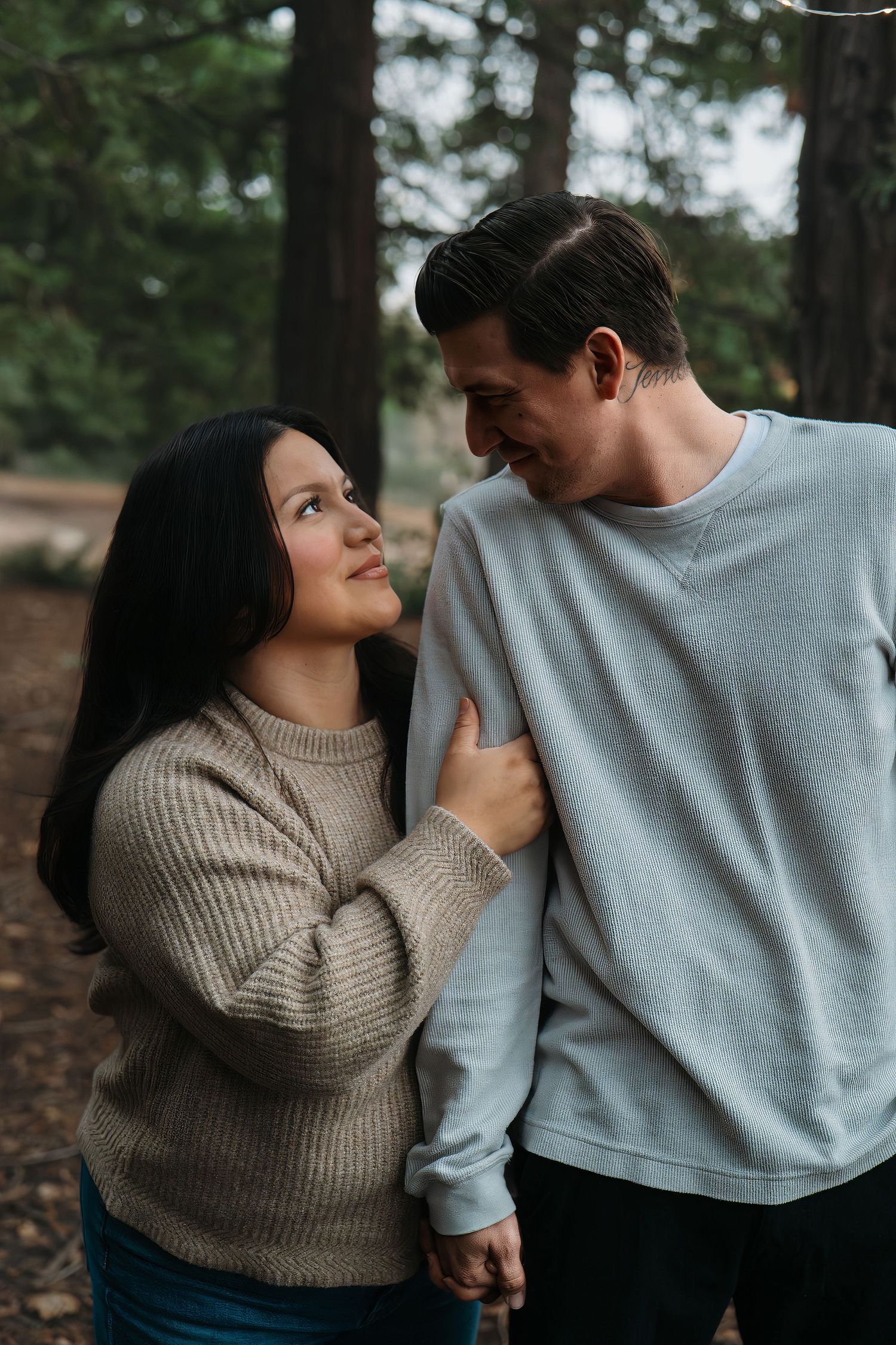 Sweet couple's photoshoot showing tender moments in casual wear among pine trees in Roseville, CA