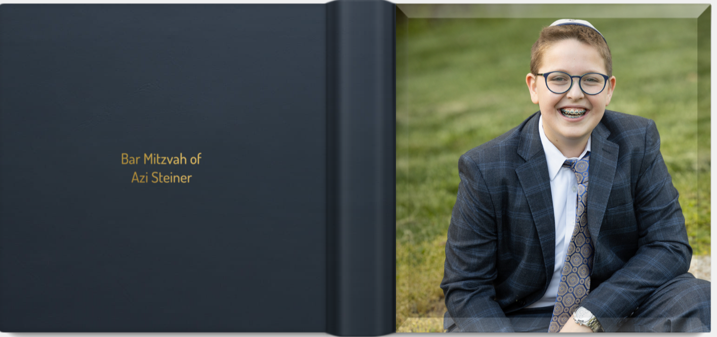Professional bar mitzvah photo album with navy blue cover and outdoor portrait on grass in formal attire.