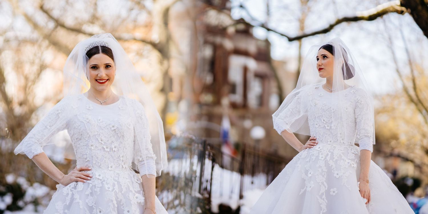 A bride in a classic white lace wedding gown twirls joyfully in an outdoor setting during a winter photo session.