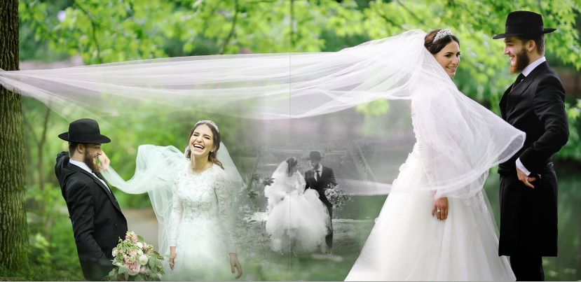 A bride and groom share a romantic moment outdoors as wind catches the flowing white wedding veil in a garden setting.
