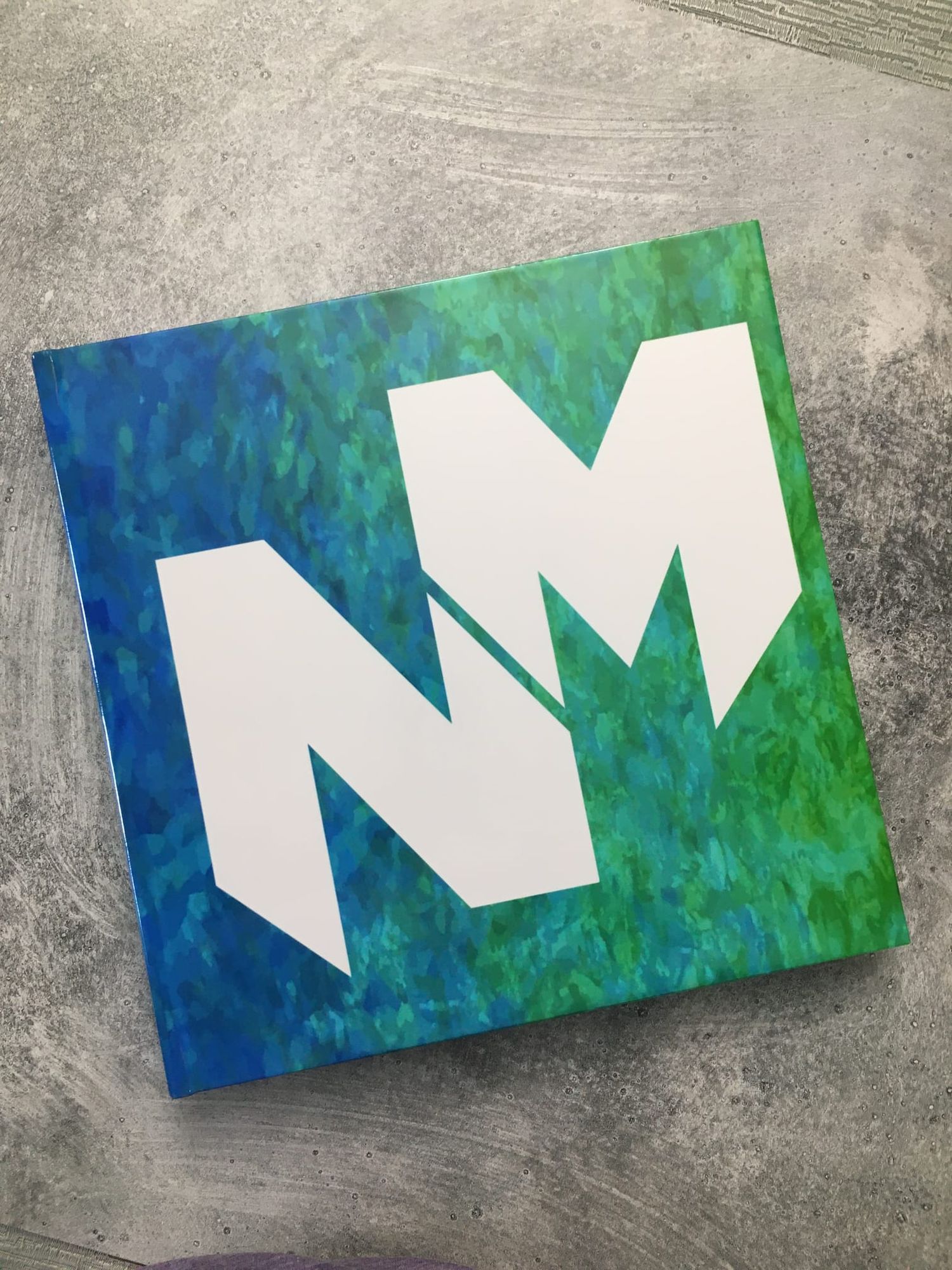 Blue and green logo cover of a bar mitzvah photo book, blending modern design with tradition.