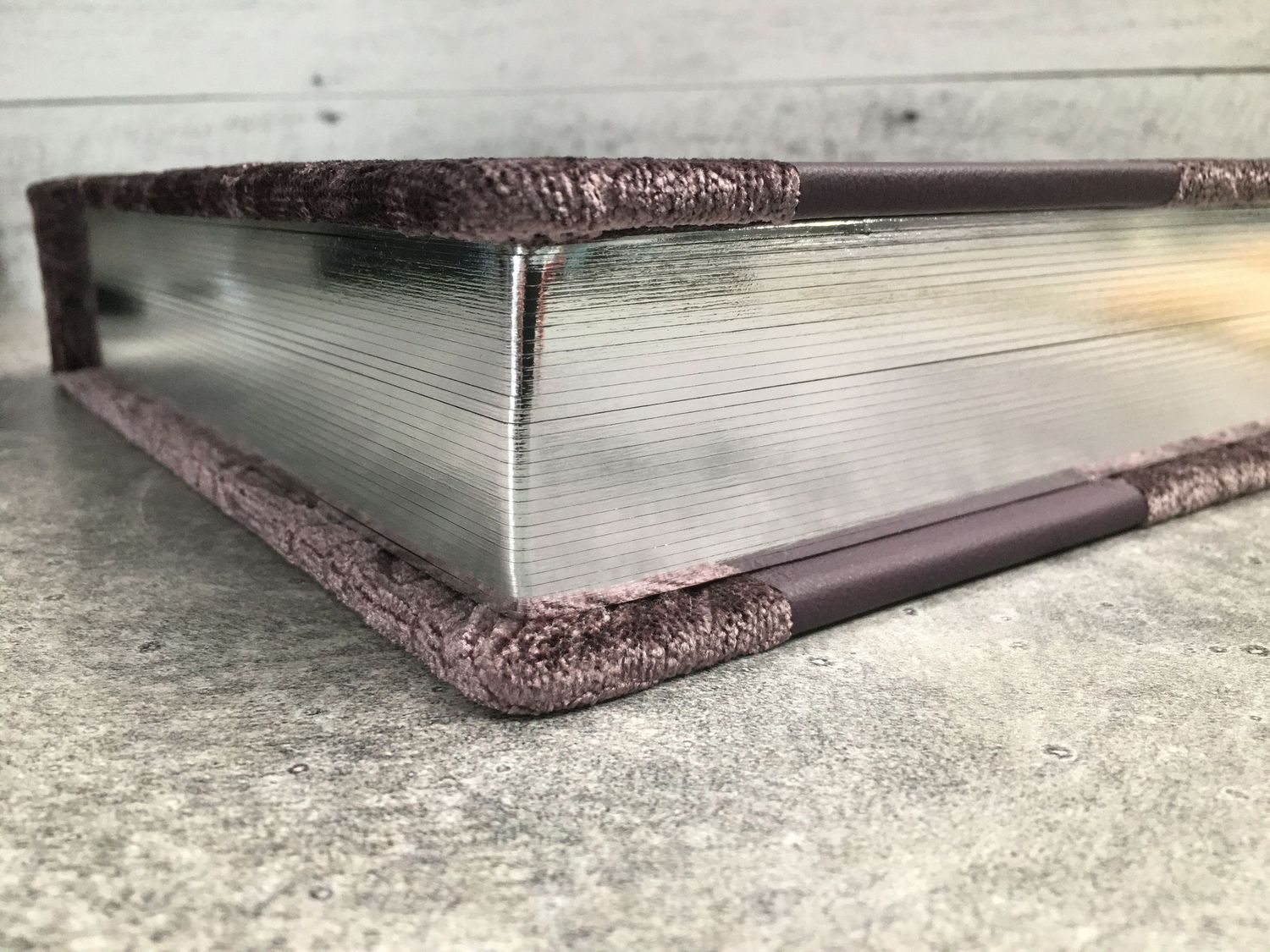 Purple textured photo album with silver page gilding, combining elegance and craftsmanship in design.