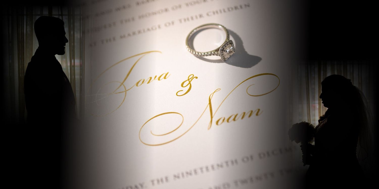 Silhouette of bride and groom displayed with their wedding invitation and diamond ring, symbolizing love and union.